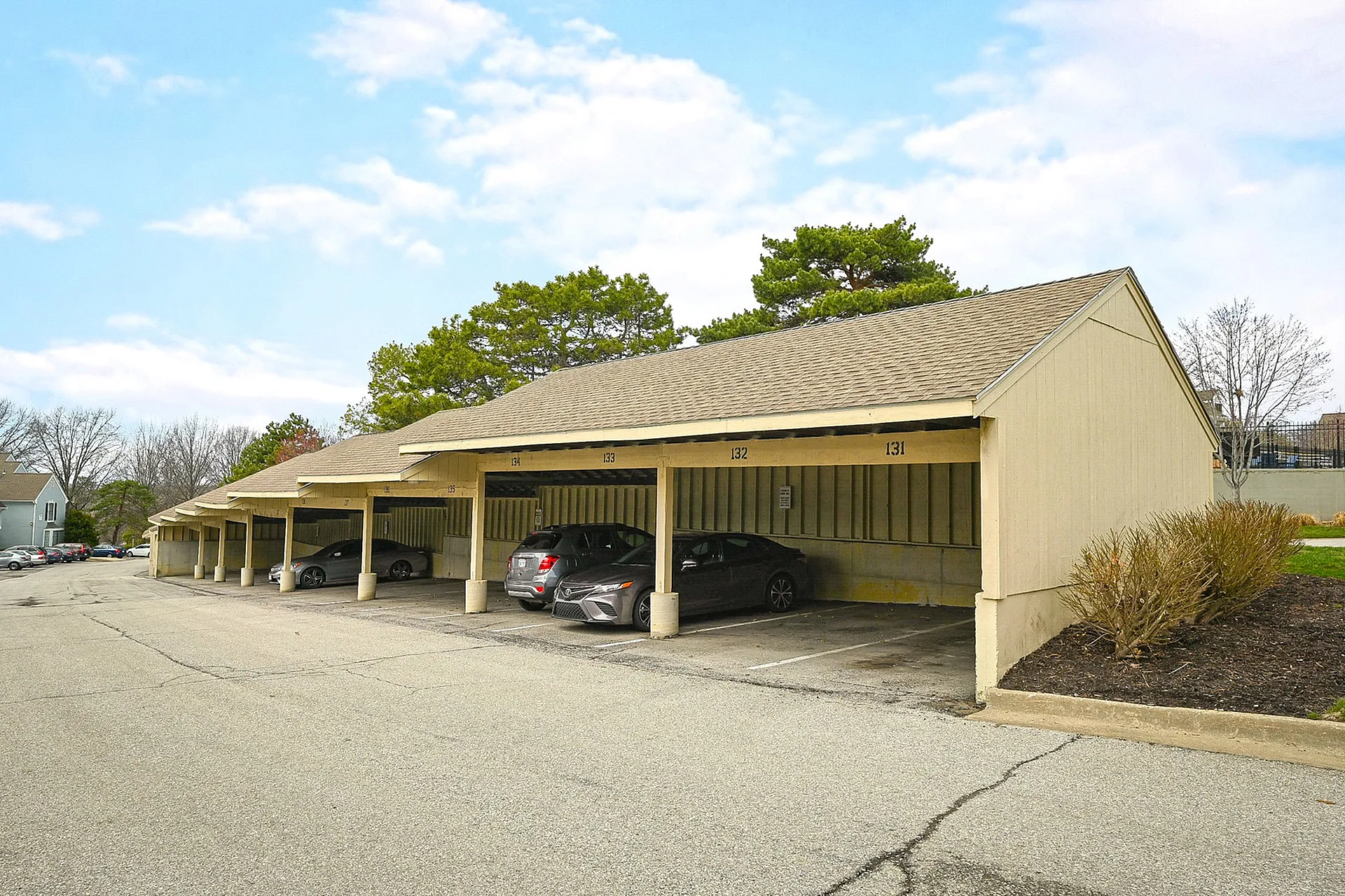 Inviting covered parking area with convenient spaces nestled in a serene residential setting.