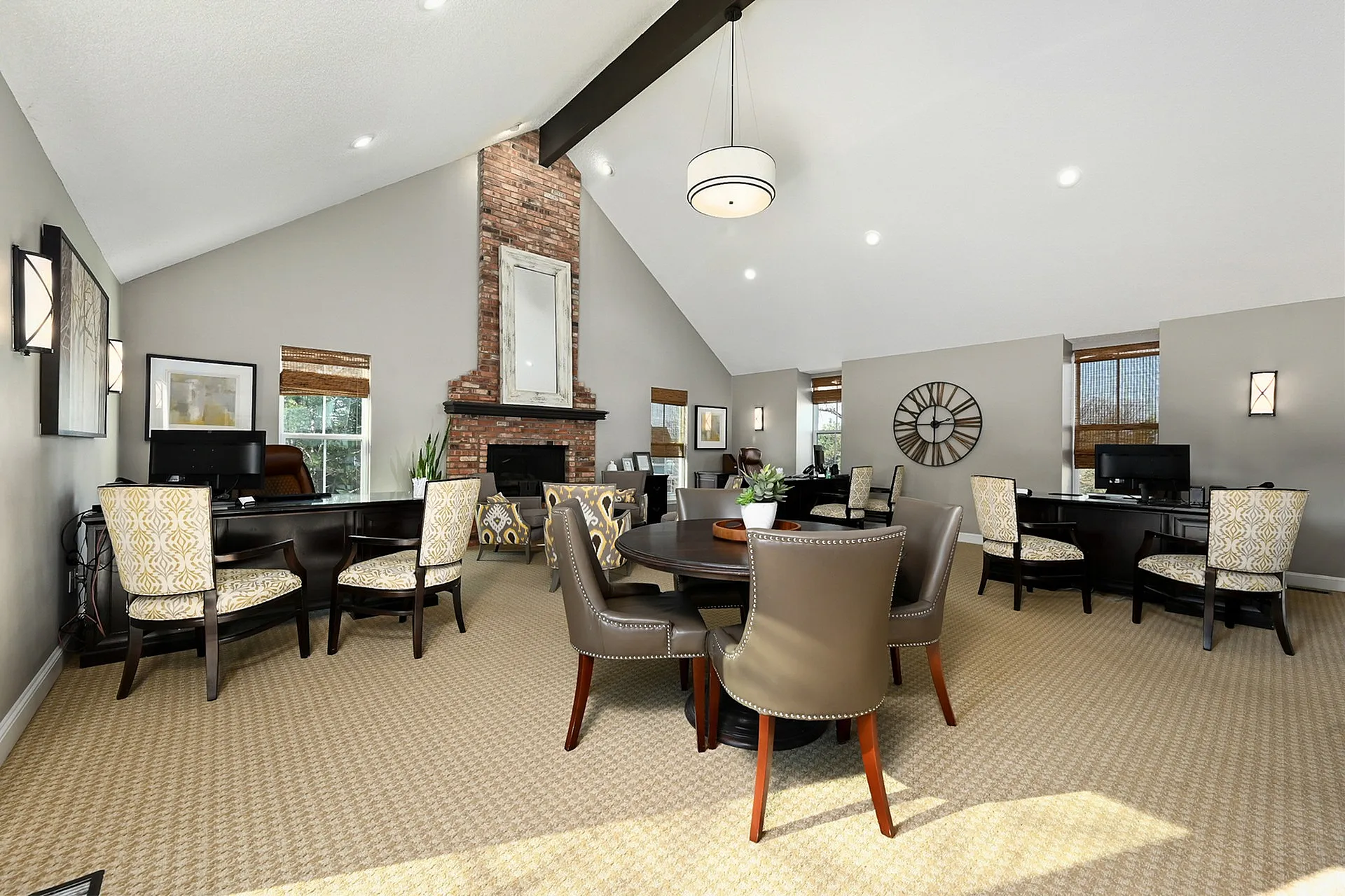 Inviting community room with elegant seating, a charming brick fireplace, and modern decor.