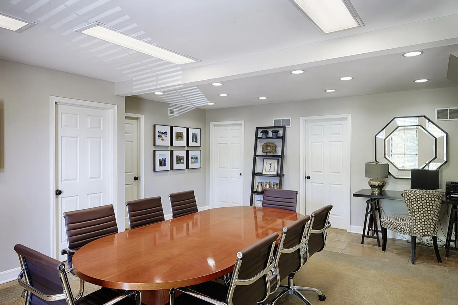 Elegant conference room with a sleek wooden table, modern chairs, and tasteful decor, perfect for professional meetings.