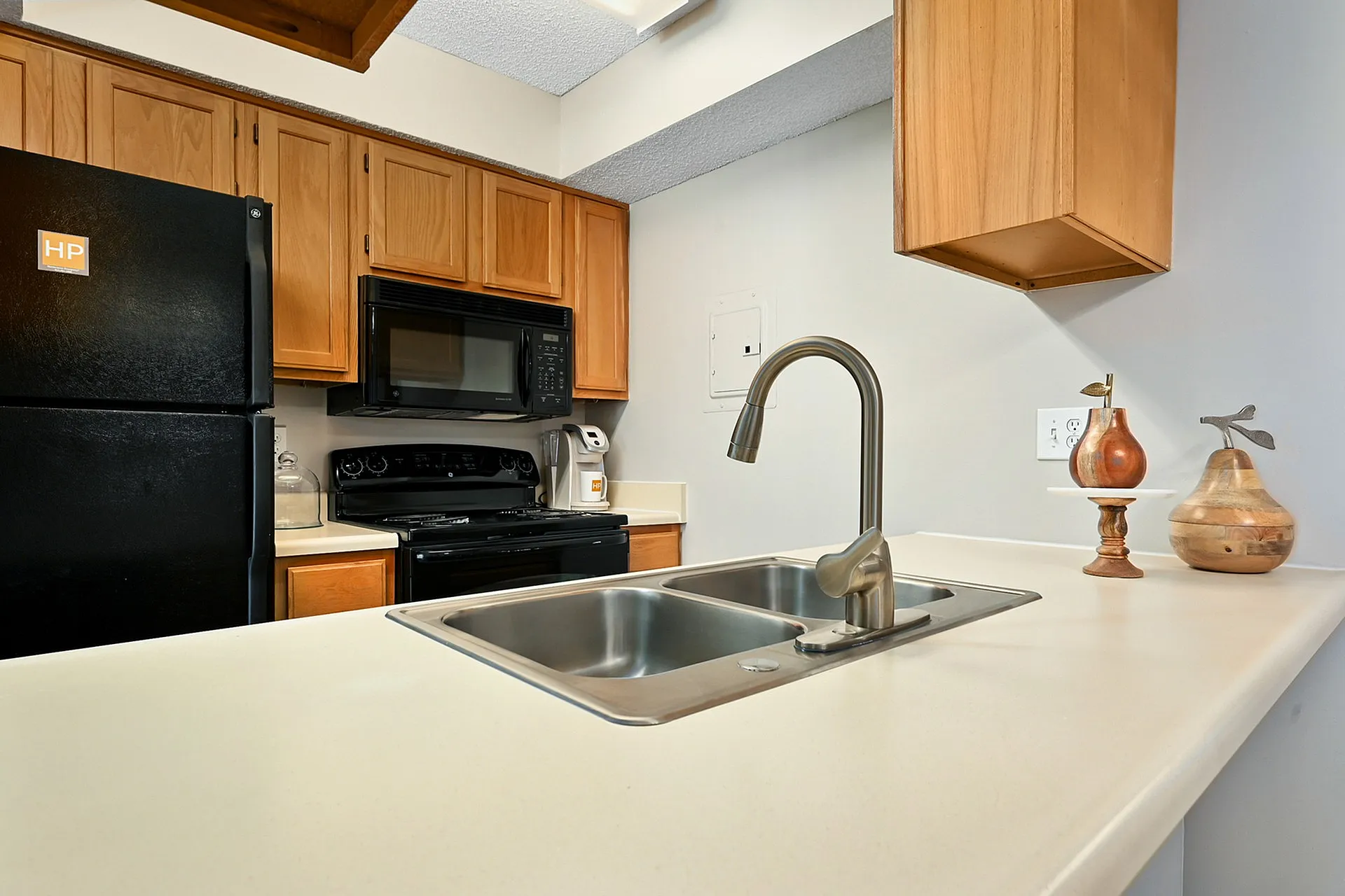 Modern kitchen with sleek black appliances, elegant wooden cabinetry, and a stylish dual sink.