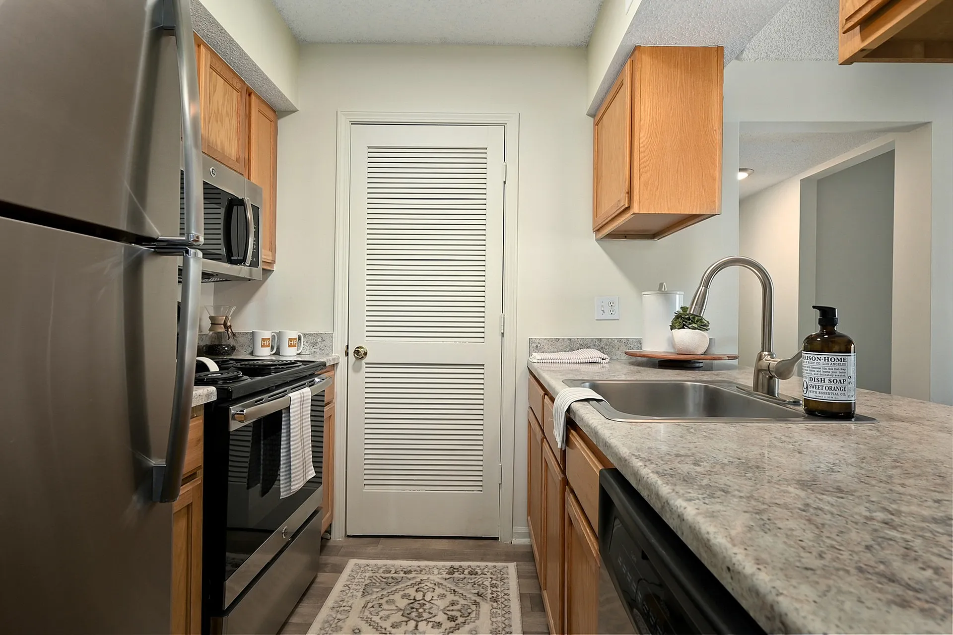 Modern kitchen with stainless steel appliances, granite countertops, and elegant wooden cabinets.