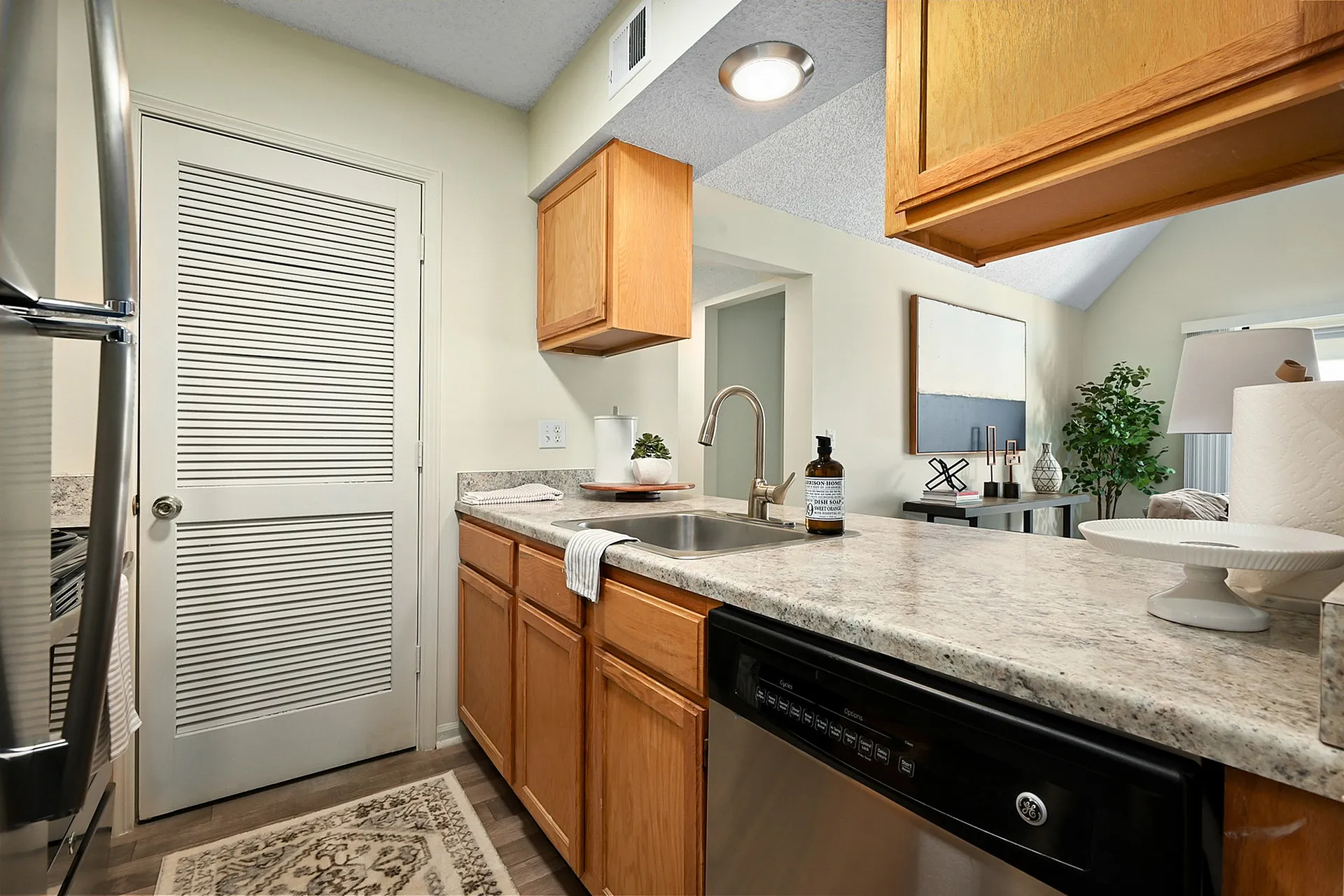 Inviting modern kitchen with granite countertops, sleek stainless steel appliances, and warm oak cabinetry.