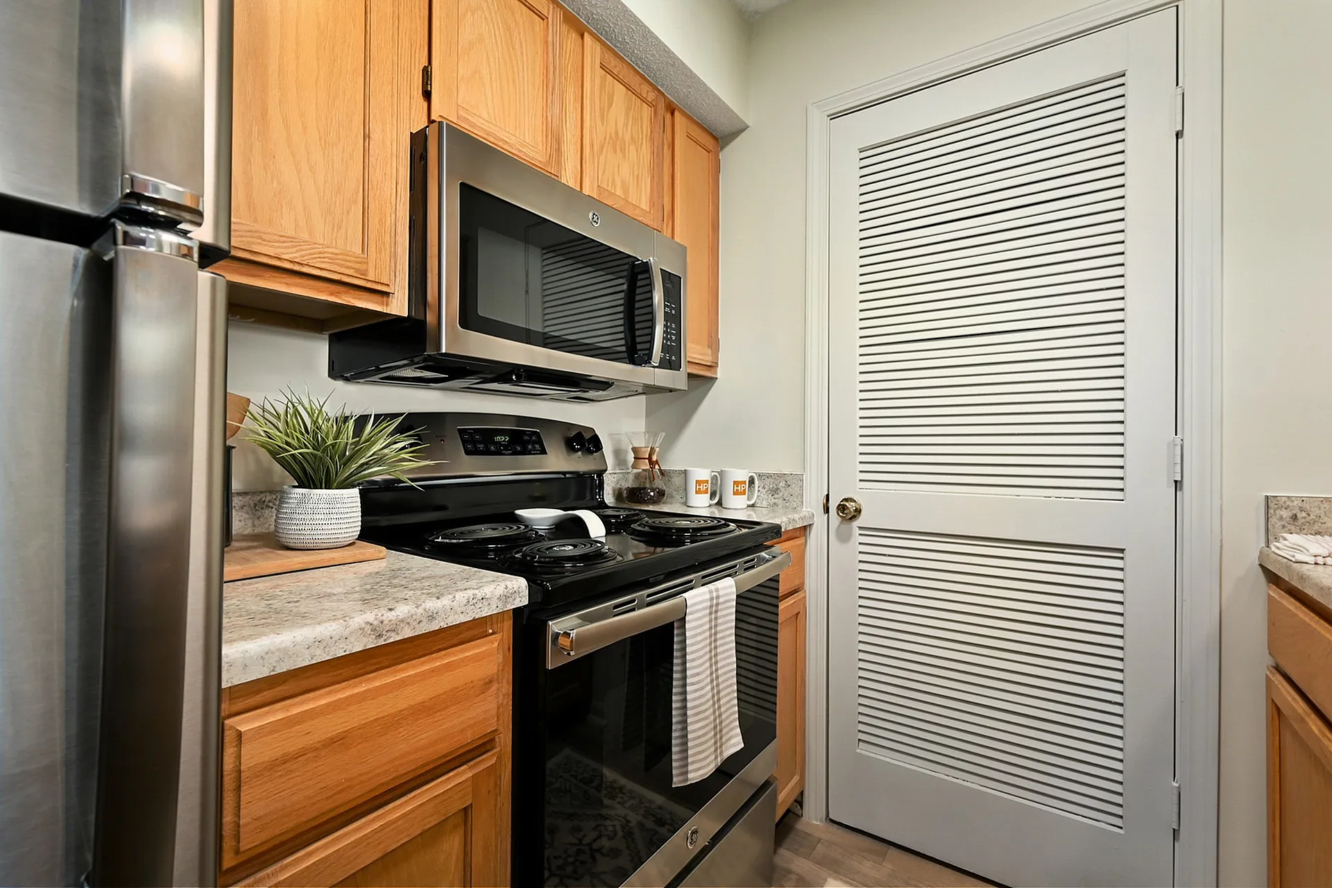 Modern kitchen with stainless steel appliances, elegant countertops, and warm wooden cabinetry.