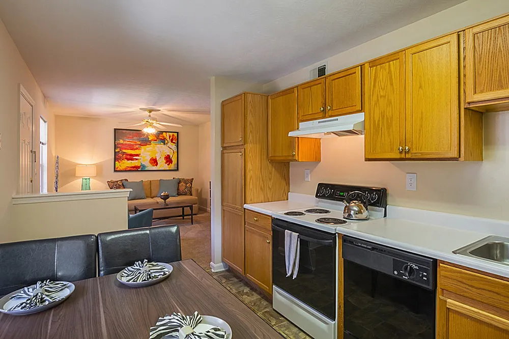 Inviting open-plan apartment featuring a cozy kitchen with wooden cabinetry, a stylish dining area, and a vibrant living room adorned with modern art.