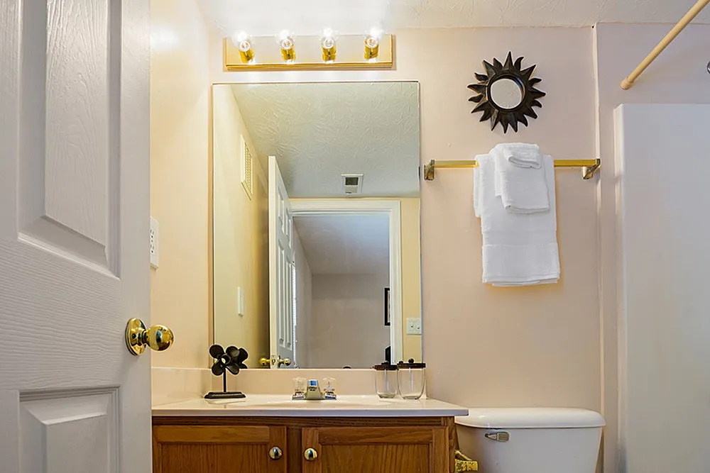 Bright and inviting bathroom with chic vanity mirror, elegant lighting, and stylish decor.