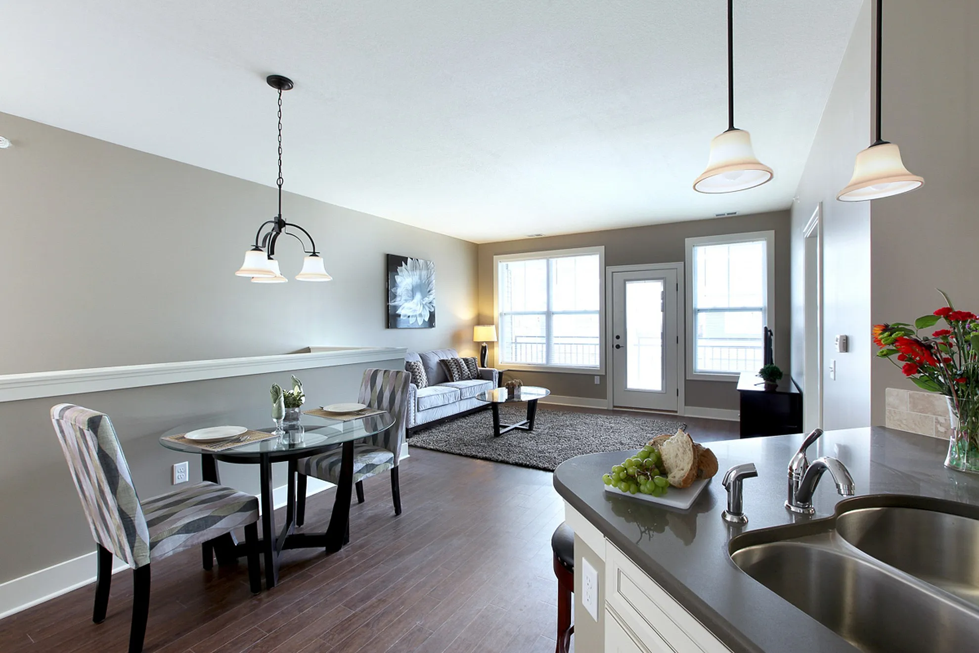 Bright and modern open-concept living area with stylish dining set, cozy seating, and elegant kitchen layout.