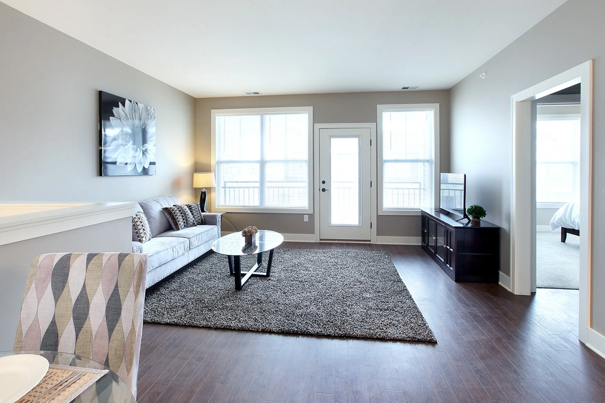 Bright and inviting living room featuring chic decor, large windows, and modern furnishings for a cozy atmosphere.