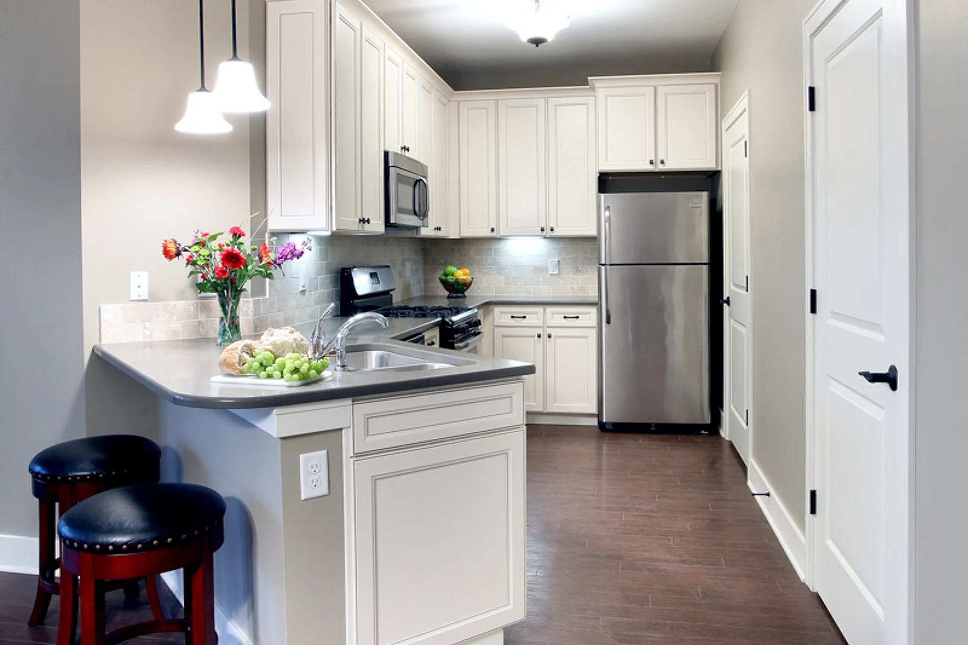 Modern kitchen with stainless steel appliances, elegant cabinetry, and stylish breakfast bar seating.