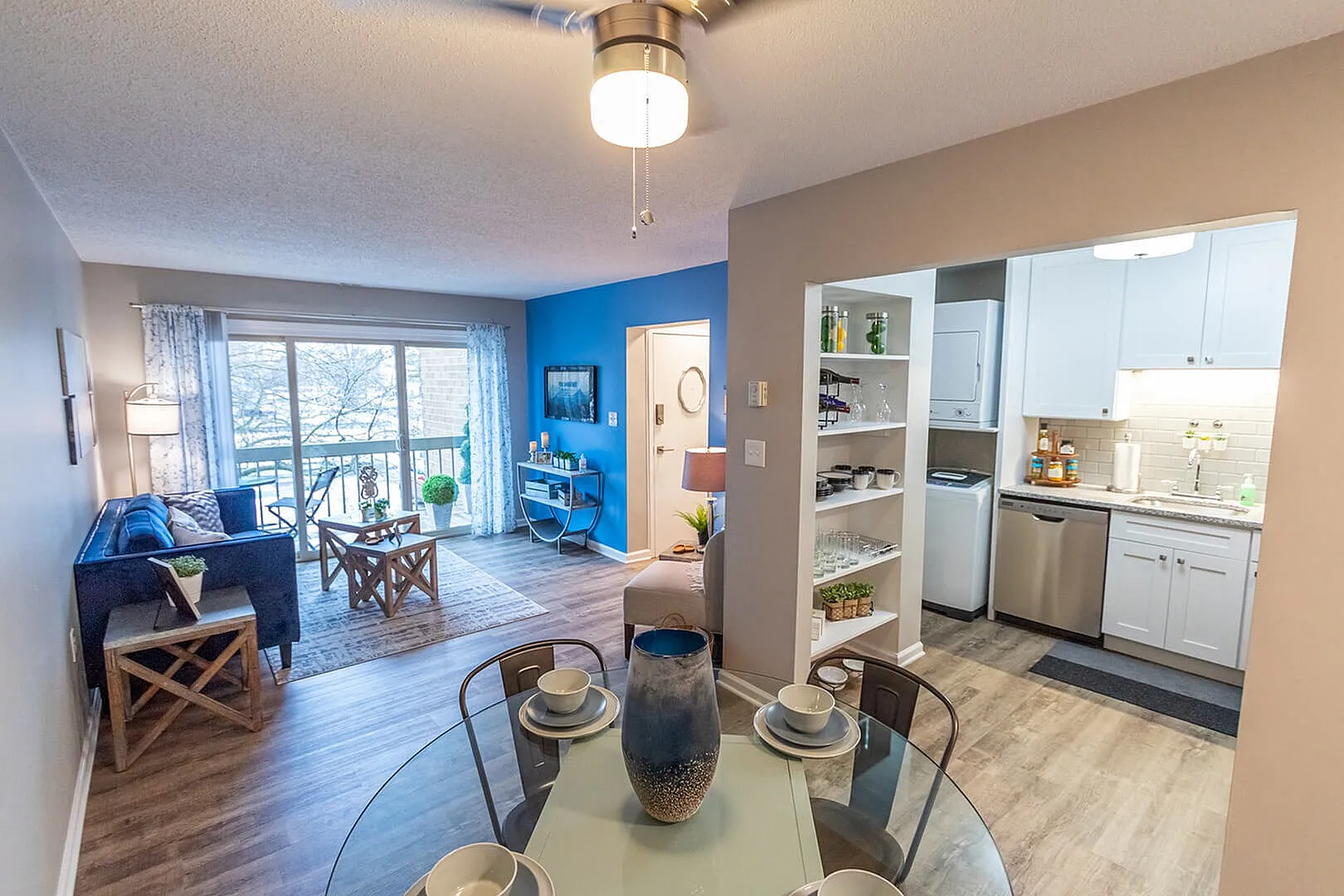 Inviting apartment living area with open-plan design, featuring a cozy lounge with balcony view, stylish kitchen, and elegant dining space.