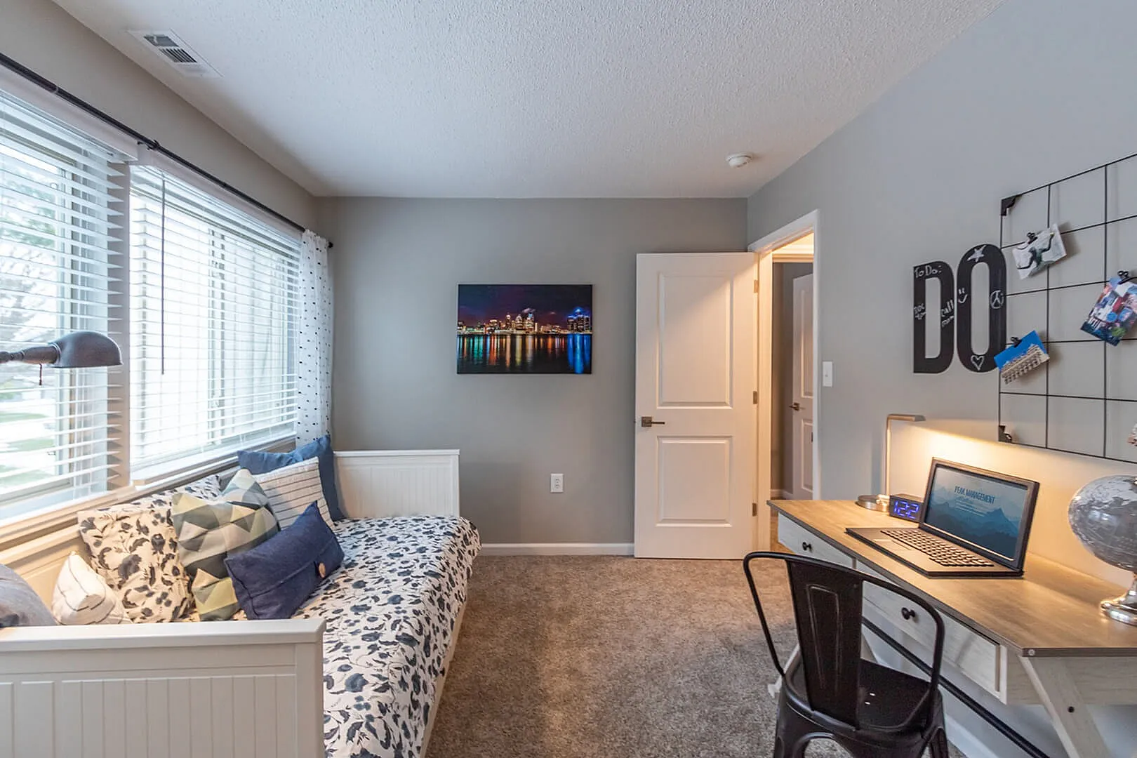 Cozy and bright home office with a comfortable daybed, chic desk setup, and large windows for natural light.