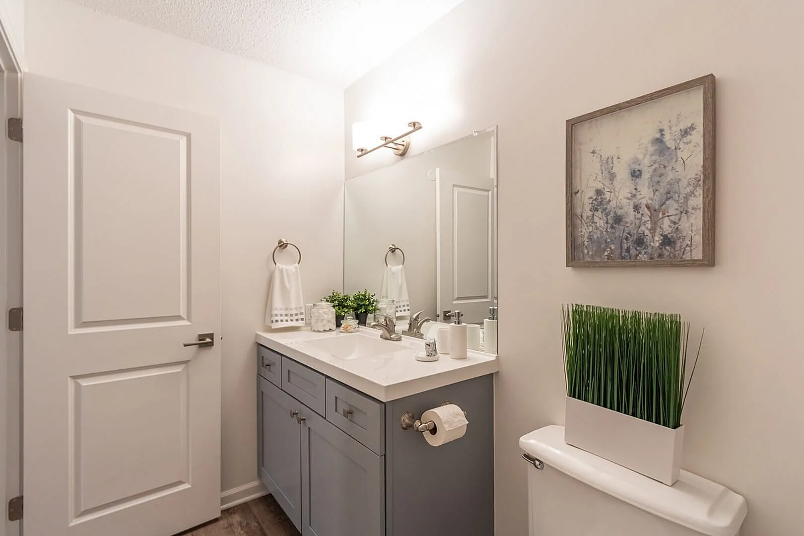 Modern bathroom with elegant vanity, large mirror, and chic decorative accents.