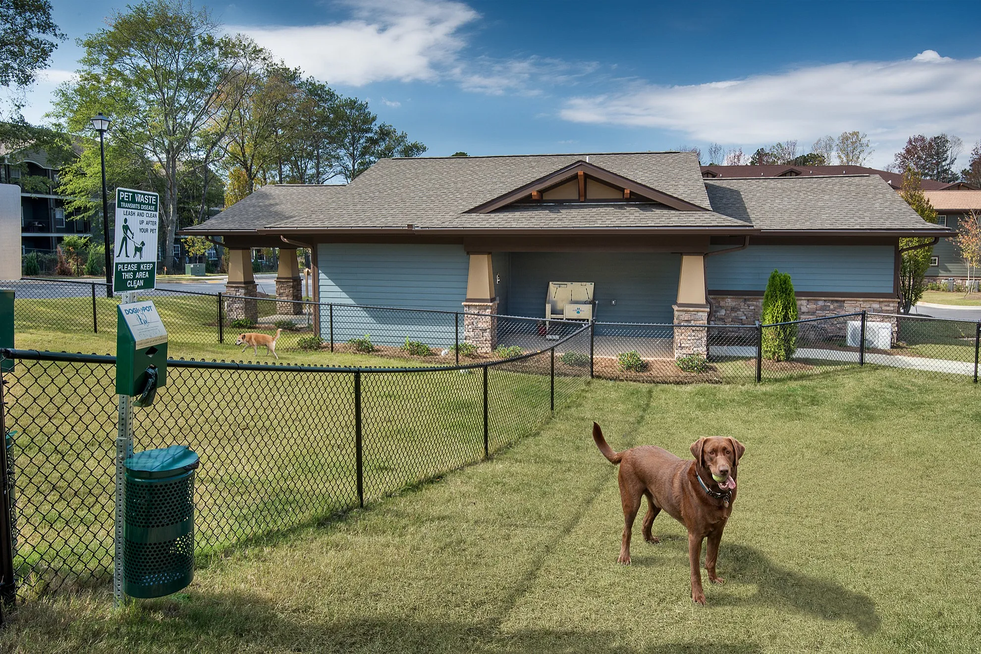 Inviting pet-friendly apartment complex with spacious fenced dog park and beautiful landscape.