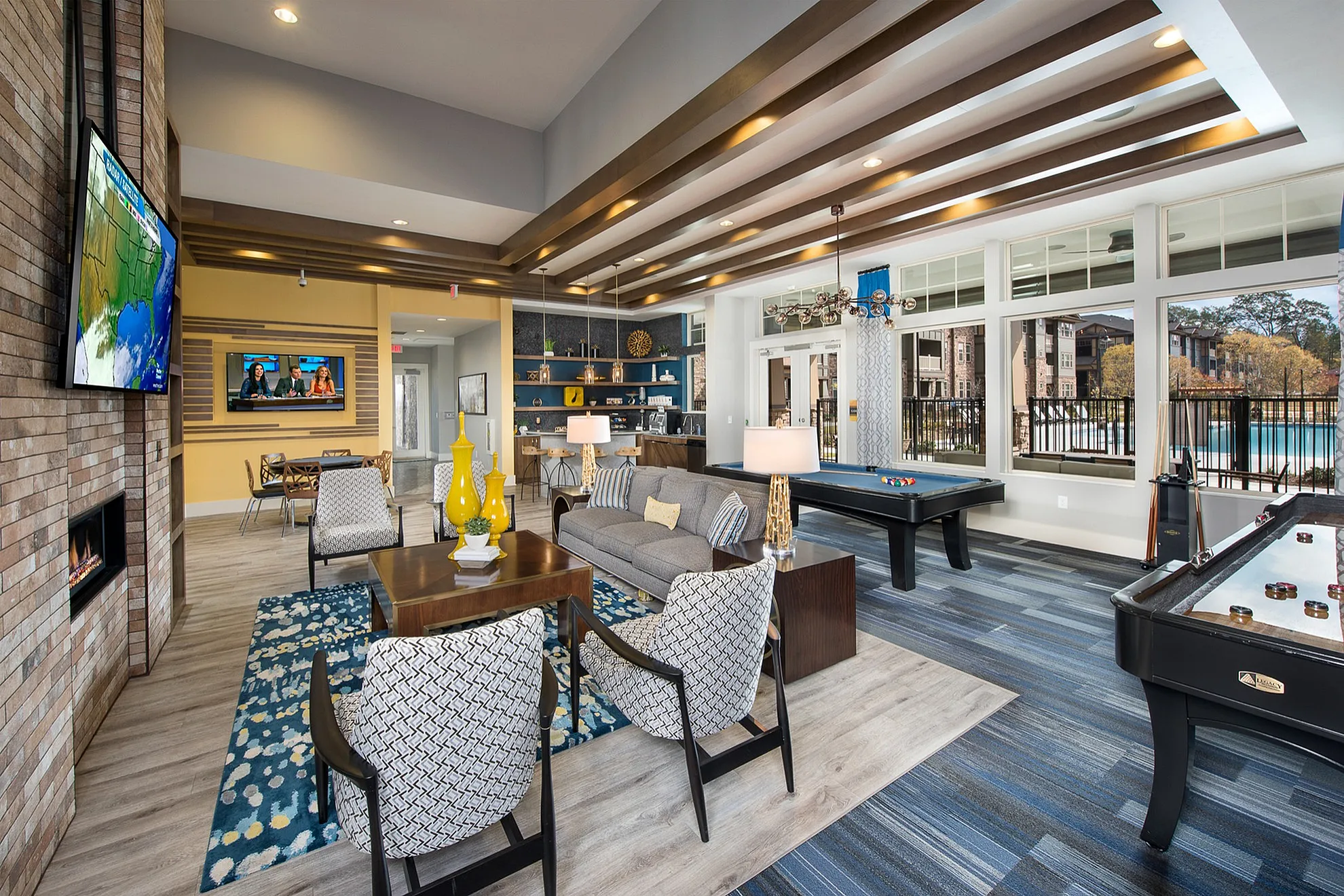 Stunning open-concept living room with modern decor, a cozy fireplace, and large windows overlooking a pool. Includes a seating area, entertainment zone, and pool table.