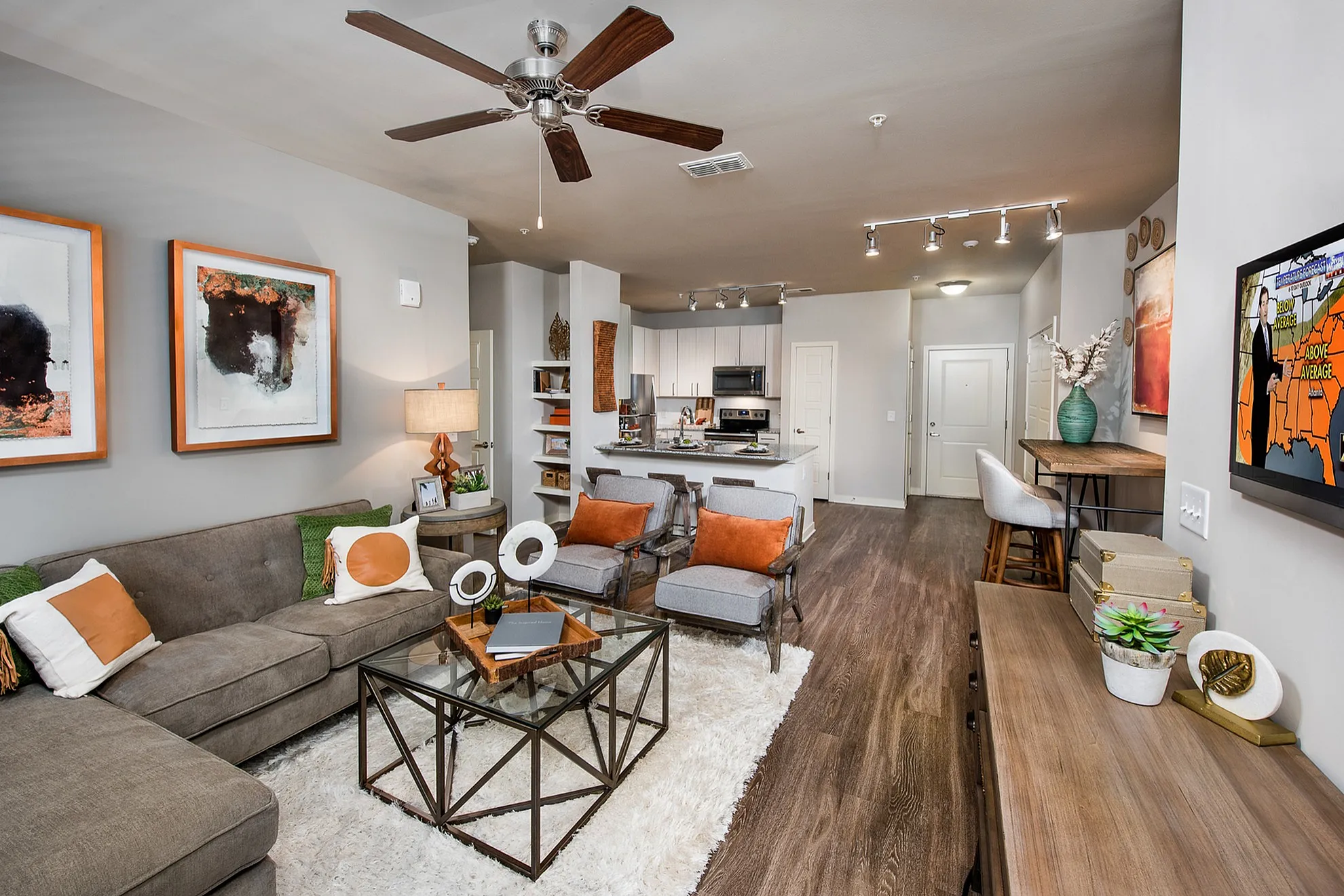 Inviting open-plan living space featuring a cozy lounge area with plush sofas, modern kitchen with sleek finishes, and stylish dining setup, perfect for comfort and entertaining.