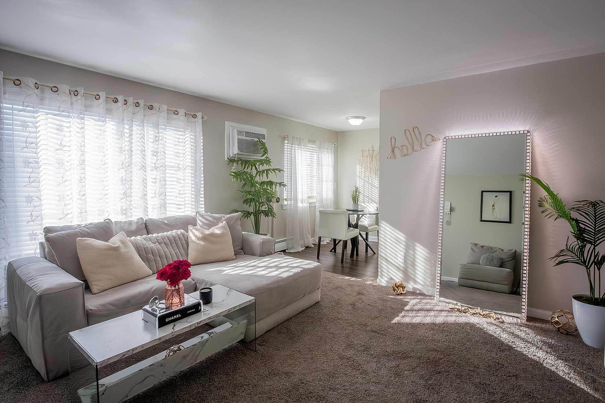 Charming living room with plush seating, elegant decor, and natural light, featuring a cozy seating area and a stylish dining nook.