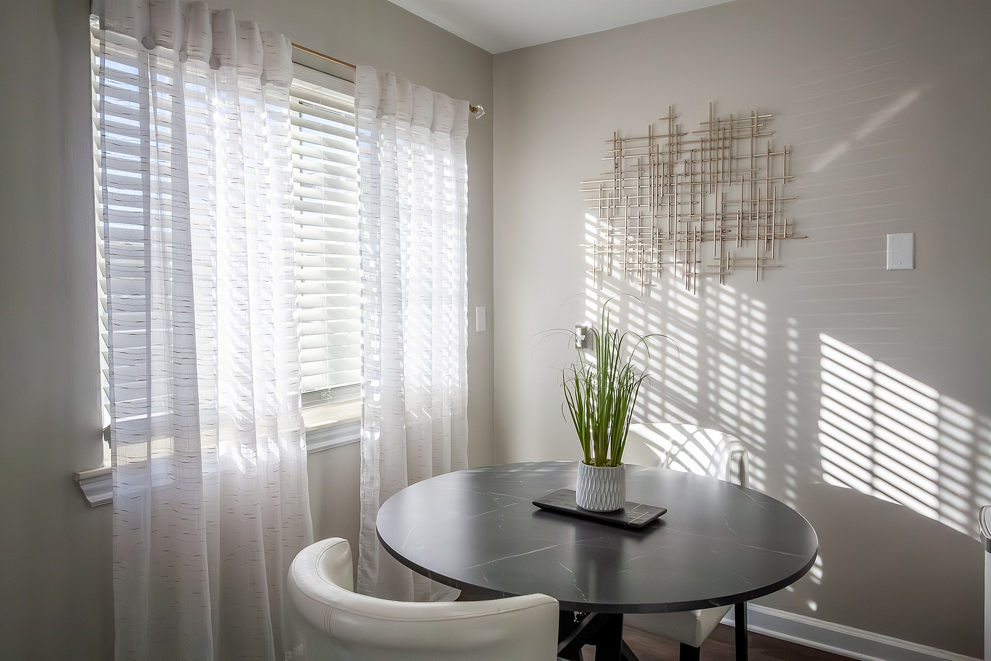 Bright and cozy dining nook featuring soft natural light, elegant curtains, and chic modern decor.