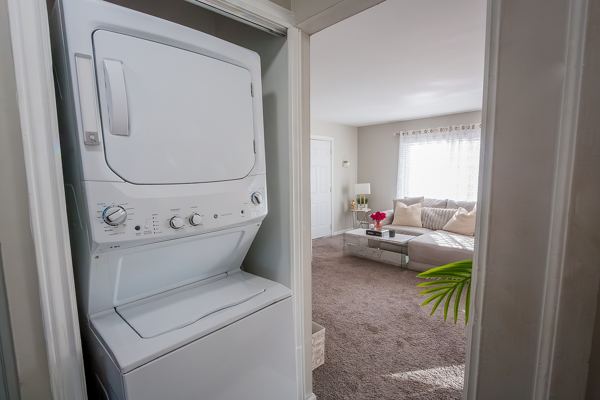 Bright living area with plush seating and in-unit washer dryer creating a cozy, convenient home vibe.