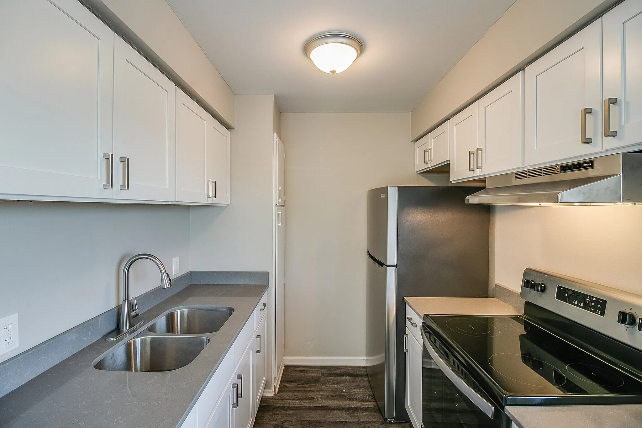 Modern kitchen with sleek stainless steel appliances, elegant countertops, and ample white cabinetry.