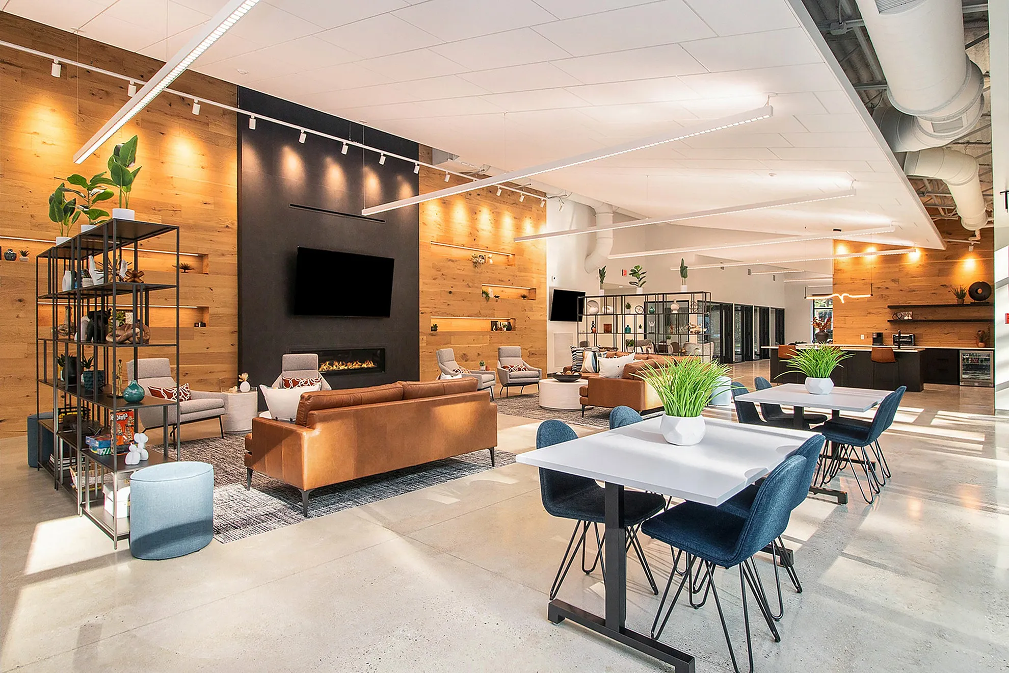 Modern communal area with stylish seating, sleek wooden panels, and vibrant greenery, embodying contemporary elegance.