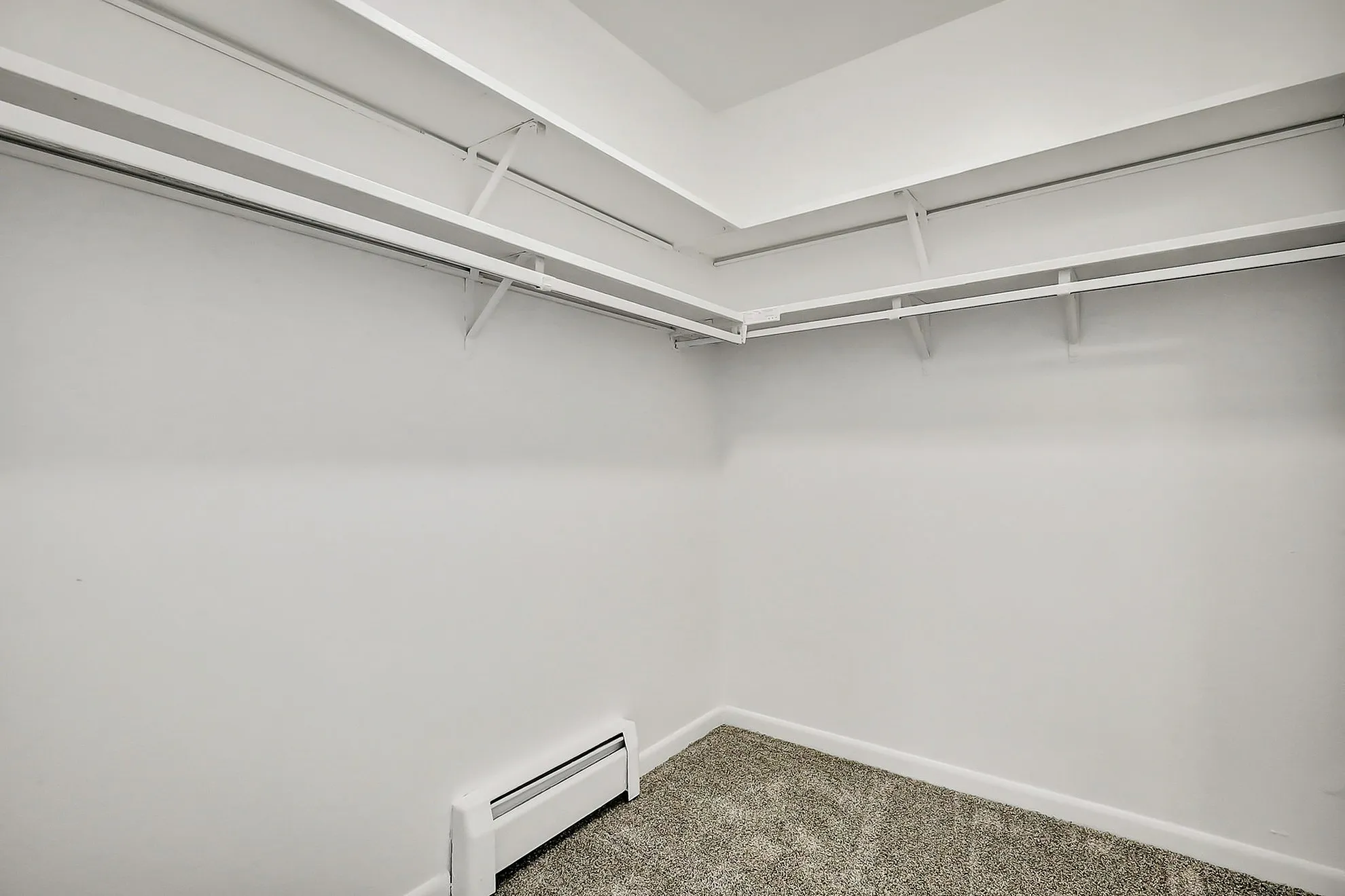 Spacious walk-in closet with ample shelving and modern design, ideal for maximizing storage in a stylish apartment.