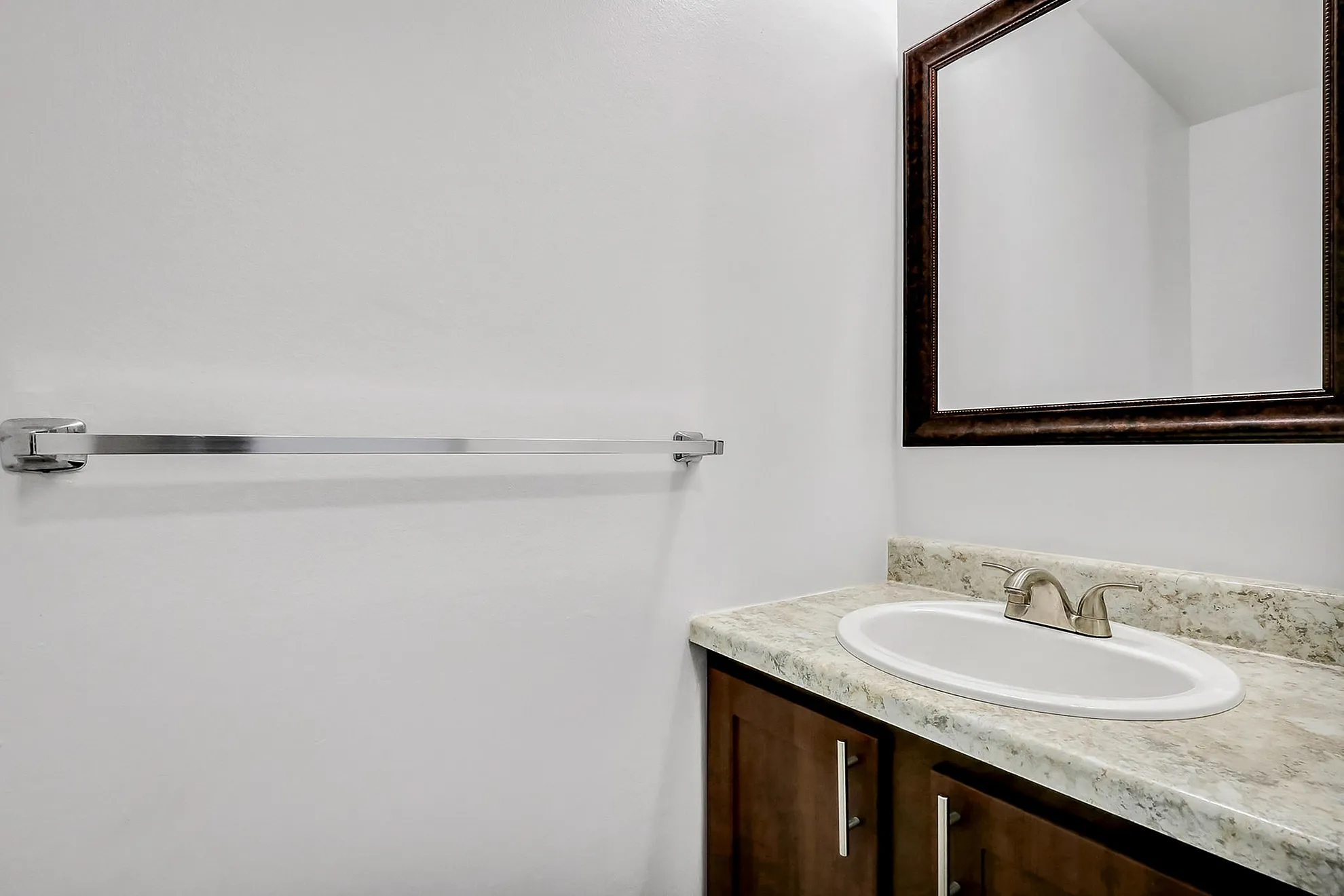 Sleek bathroom design featuring a modern vanity with a marble countertop, polished metal faucet, and large framed mirror.