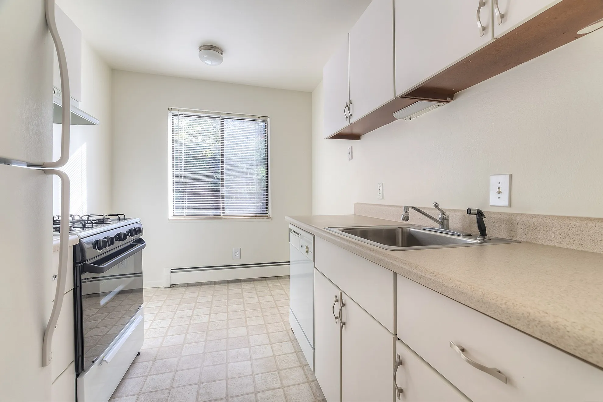 Bright and cozy kitchen featuring modern appliances, ample counter space, and natural light from a large window.