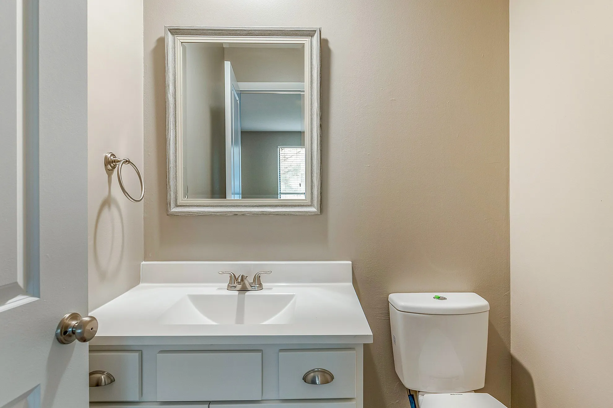 Bright and modern bathroom with elegant mirror, sleek vanity, and classic fixtures.