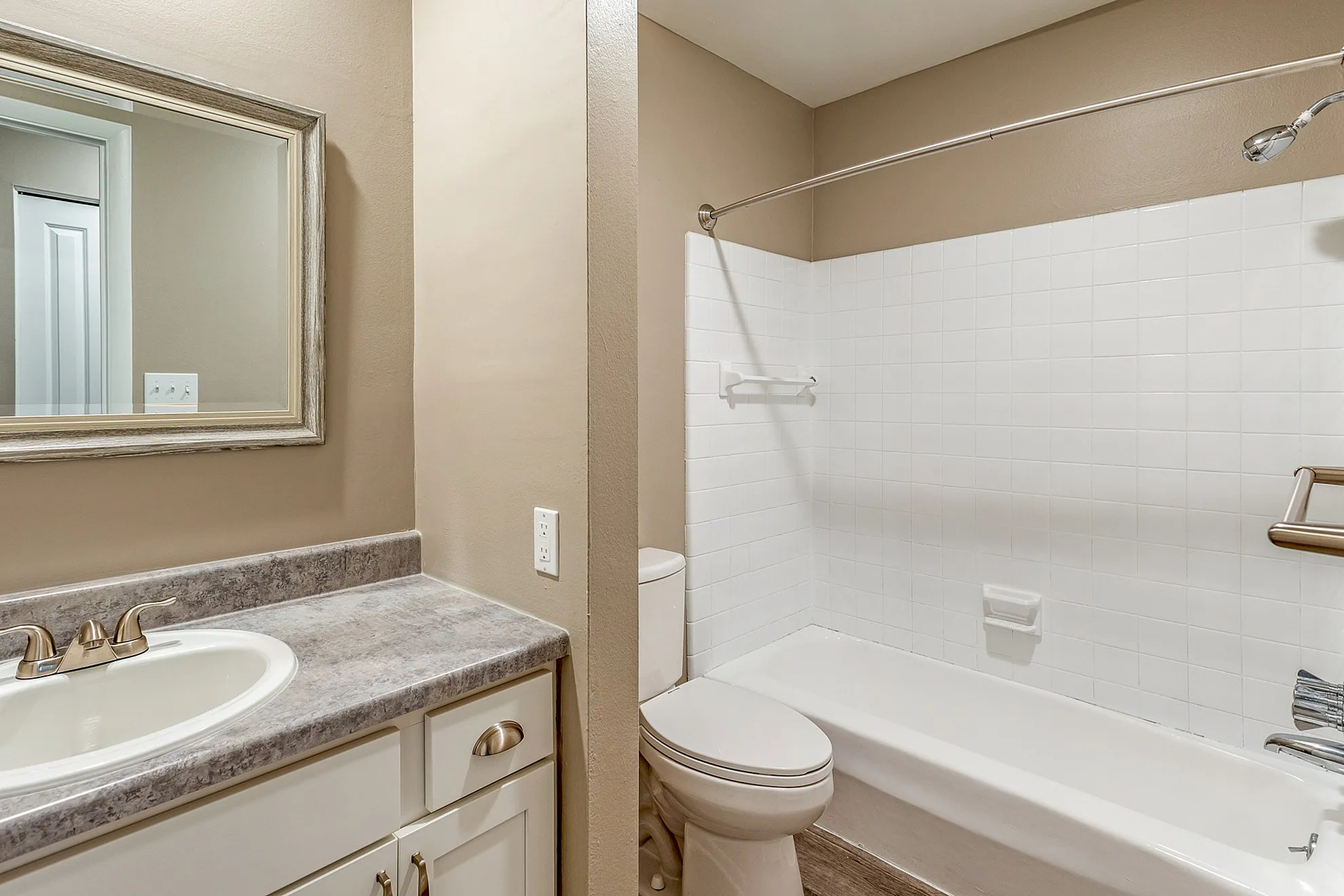 Elegant bathroom featuring a polished countertop, modern fixtures, and a sleek bathtub with a high-end tiled wall.