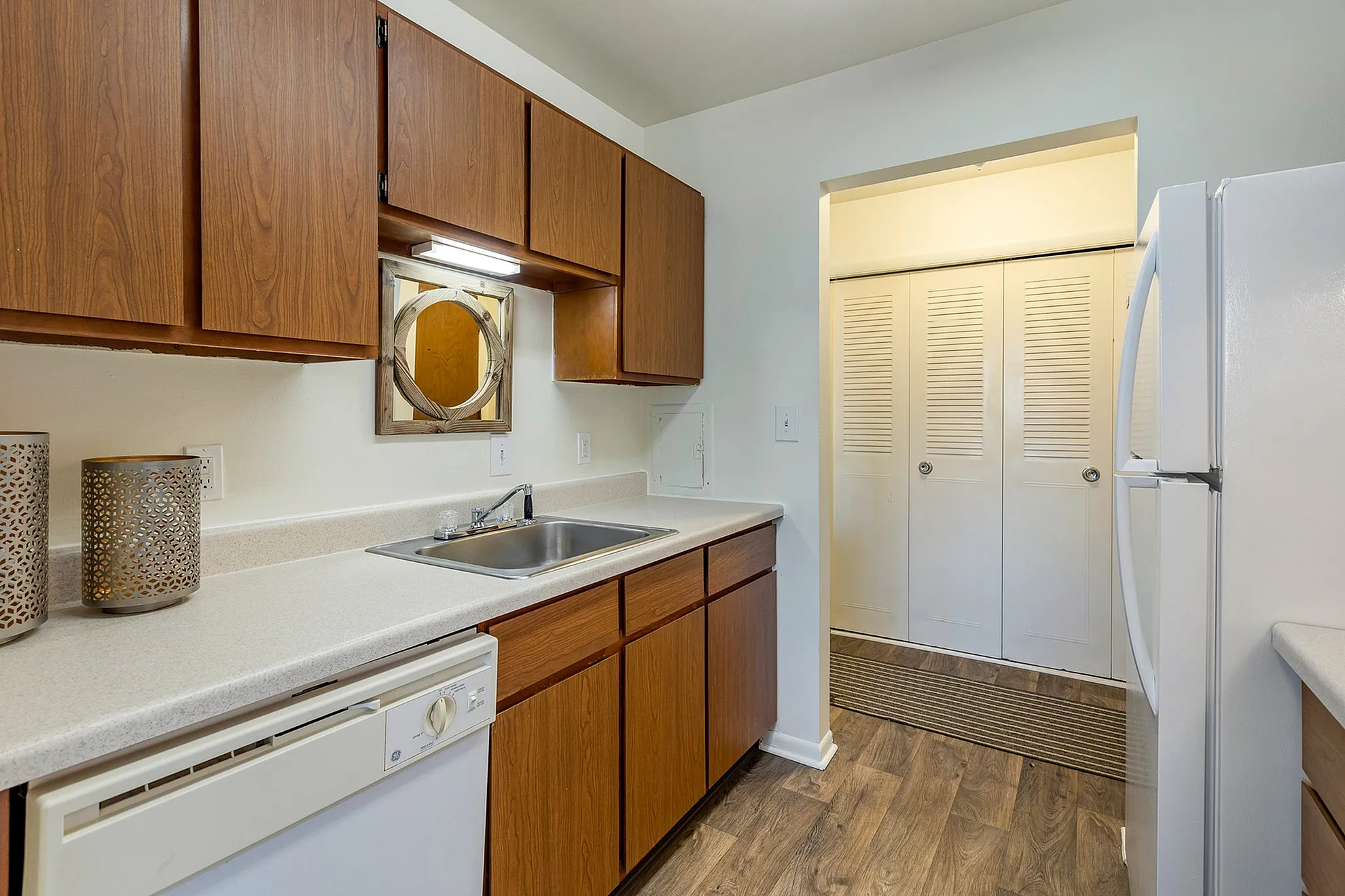 Charming kitchen with warm wooden cabinets, modern white countertops, and sleek appliances, perfect for culinary adventures.