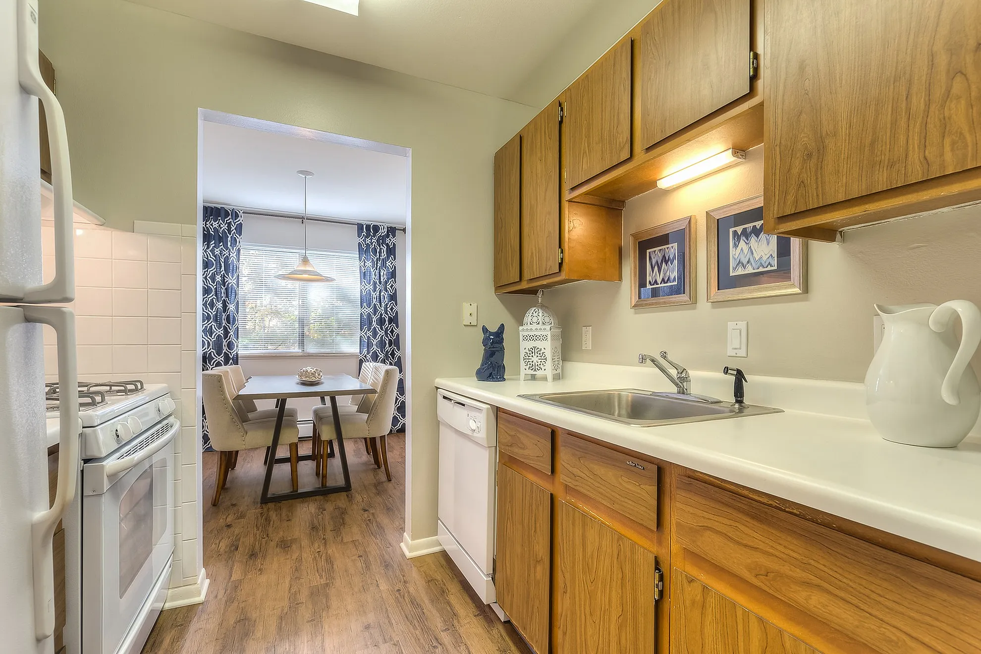 Inviting kitchen with warm wooden cabinets and a cozy dining nook featuring elegant decor and soft lighting.