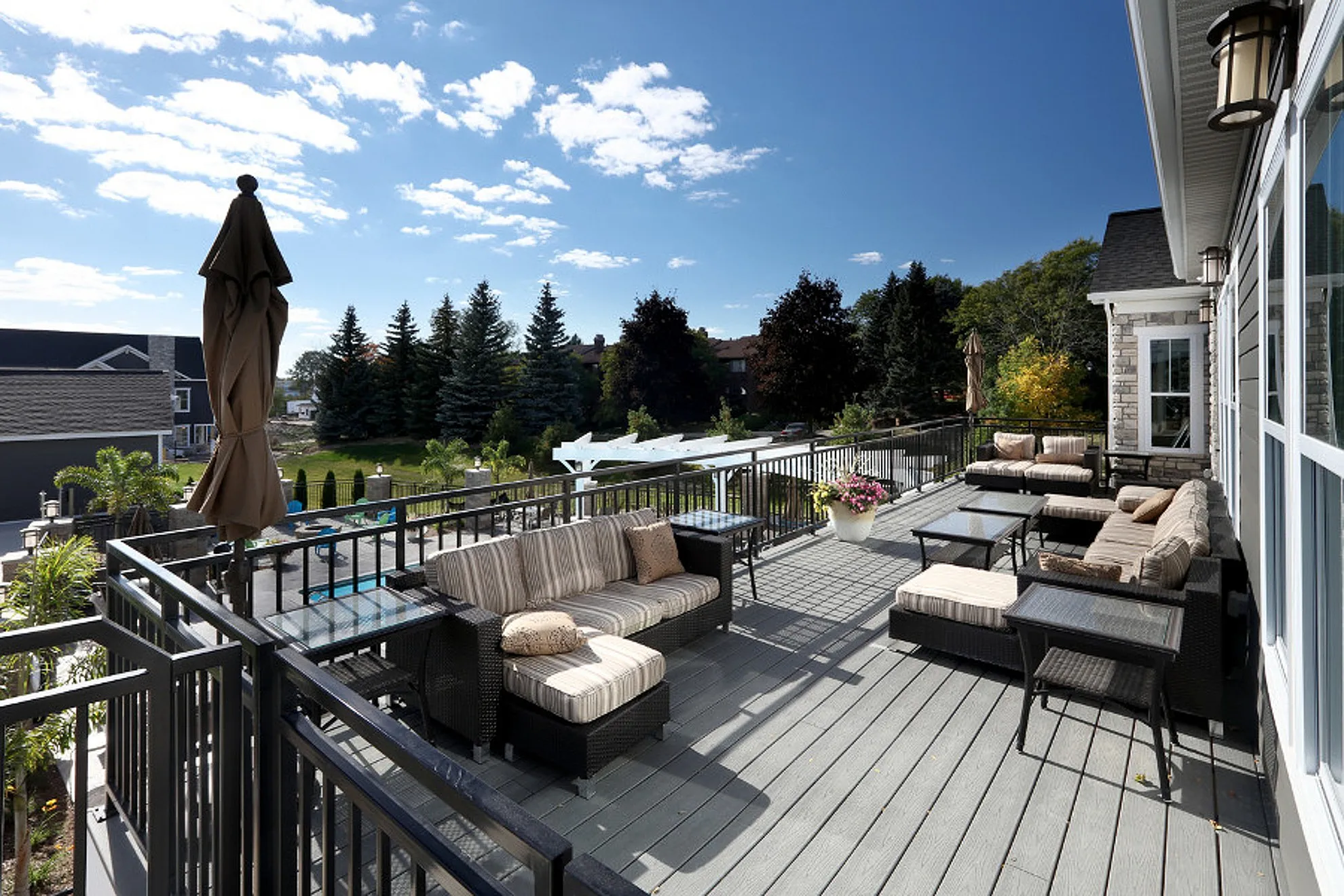 Charming outdoor patio with stylish seating, scenic views, and lush greenery under a clear blue sky.