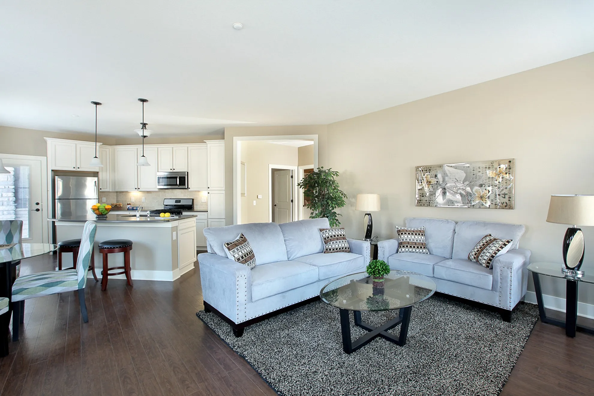 Contemporary open-plan living area with elegant furnishings, sleek kitchen with stainless steel appliances, and stylish neutral decor.