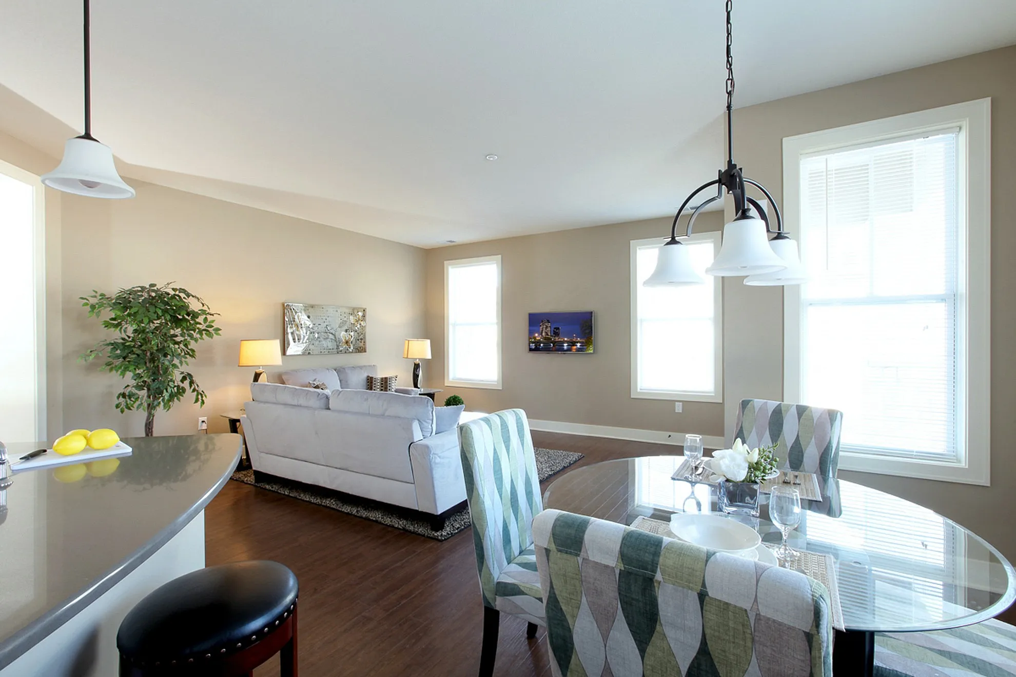 Bright and inviting open-plan living and dining area with modern decor, large windows, and elegant lighting.