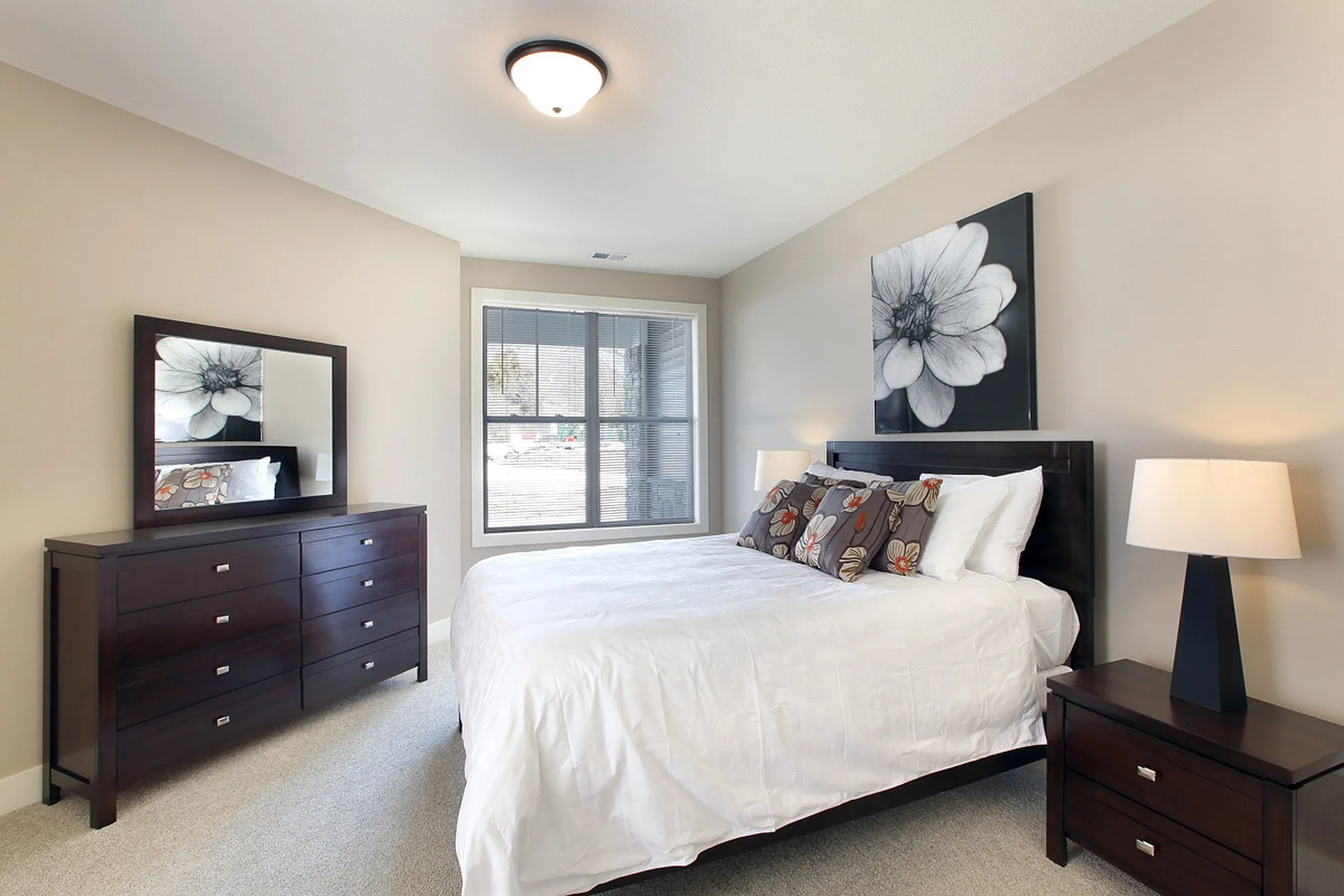 Elegant bedroom with chic décor, featuring a comfortable bed, modern dresser, and contemporary artwork, creating a serene and inviting atmosphere.