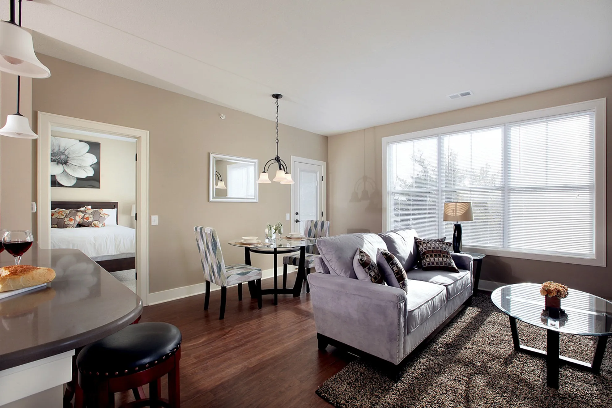 Elegant open-concept living room with natural light, a cozy dining area, and stylish decor.
