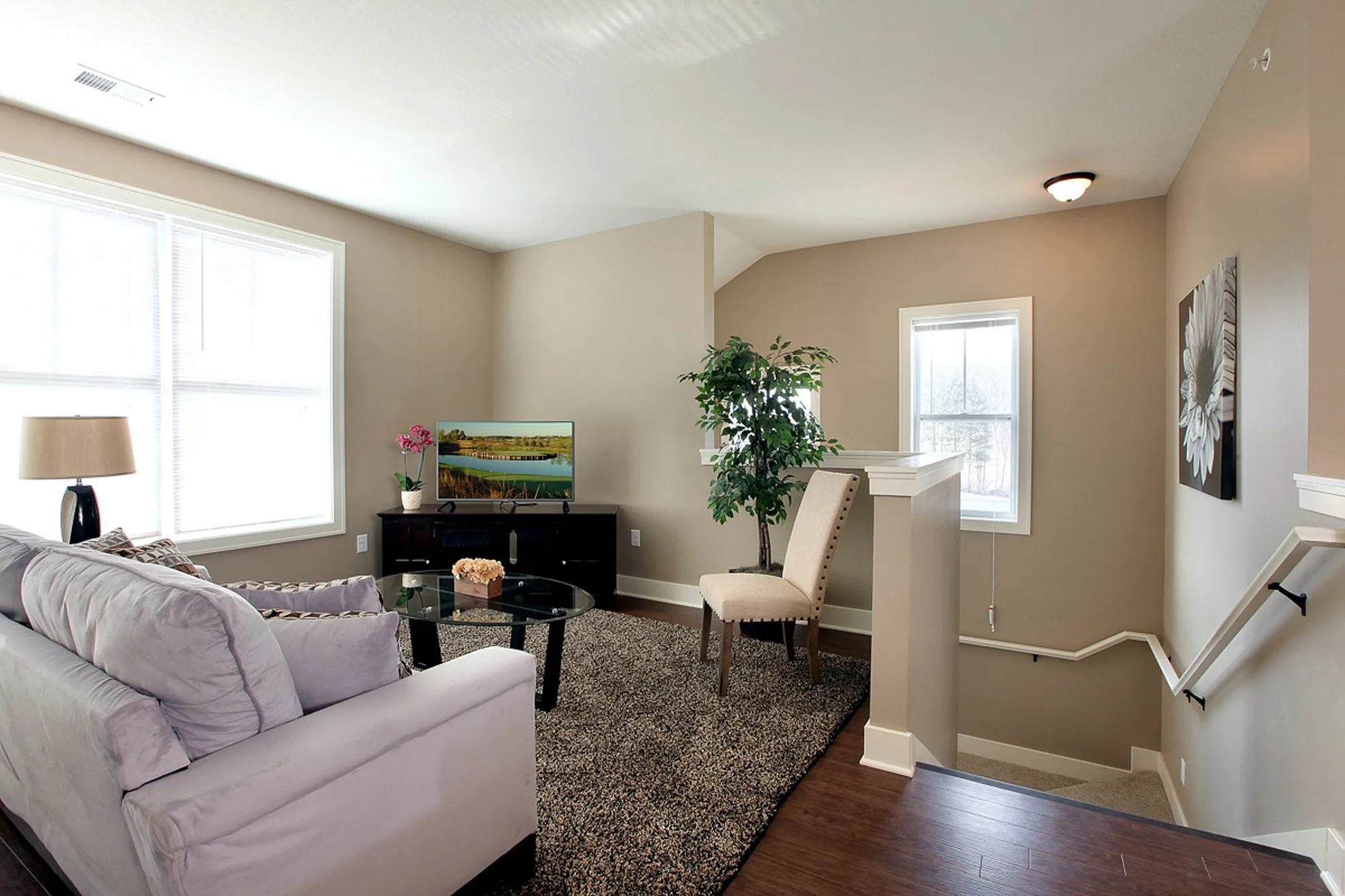 Inviting living room with plush sofa, elegant decor, and natural light pouring in through large windows.
