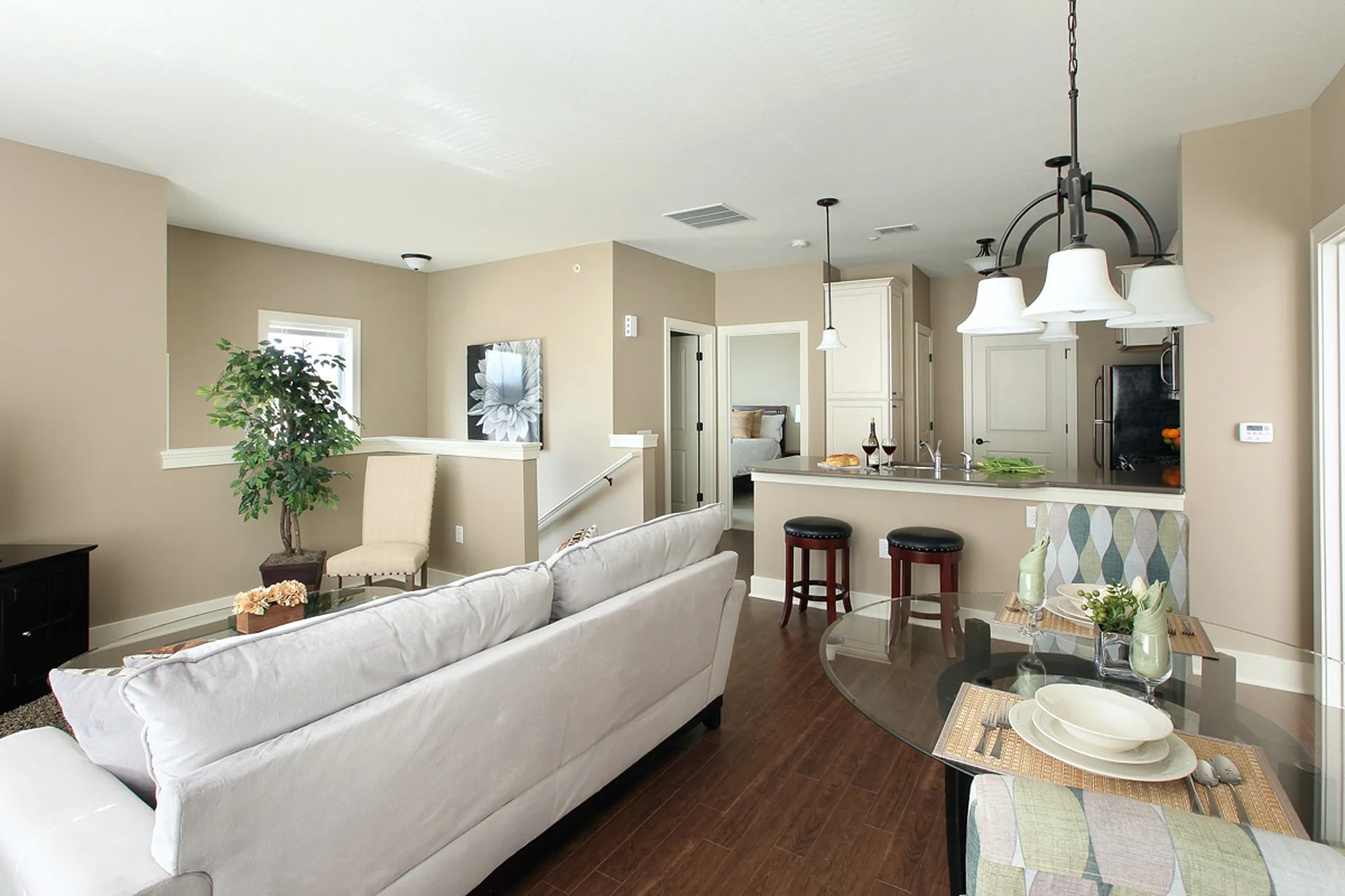 Modern open-concept living space with elegant kitchen island, cozy seating, and dining area accented by stylish lighting and natural decor.