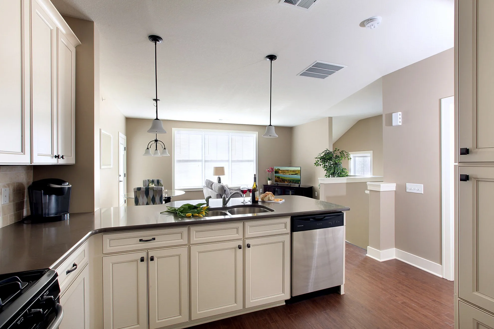 Bright and modern kitchen with sleek countertops, stainless steel appliances, and open living area, perfect for entertaining.