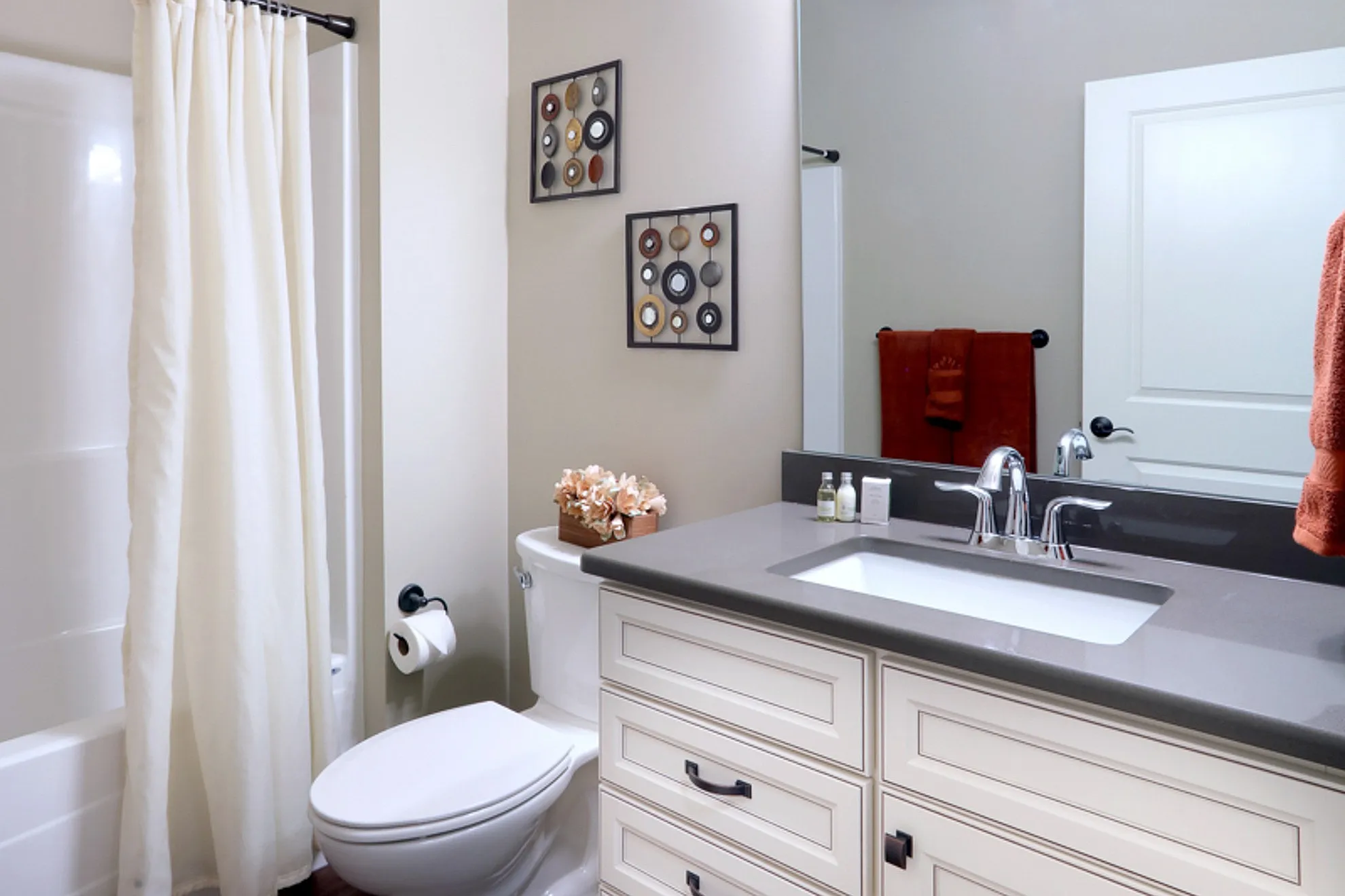 Modern bathroom with elegant vanity, sleek fixtures, and tasteful wall art.