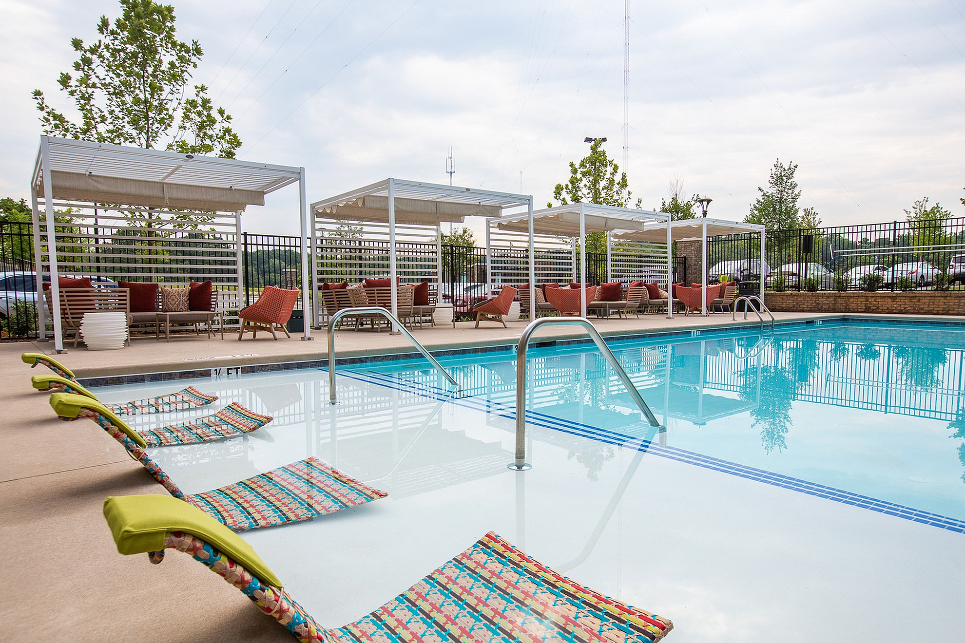 Luxurious outdoor pool area with stylish lounge chairs and elegant cabanas, perfect for relaxation.