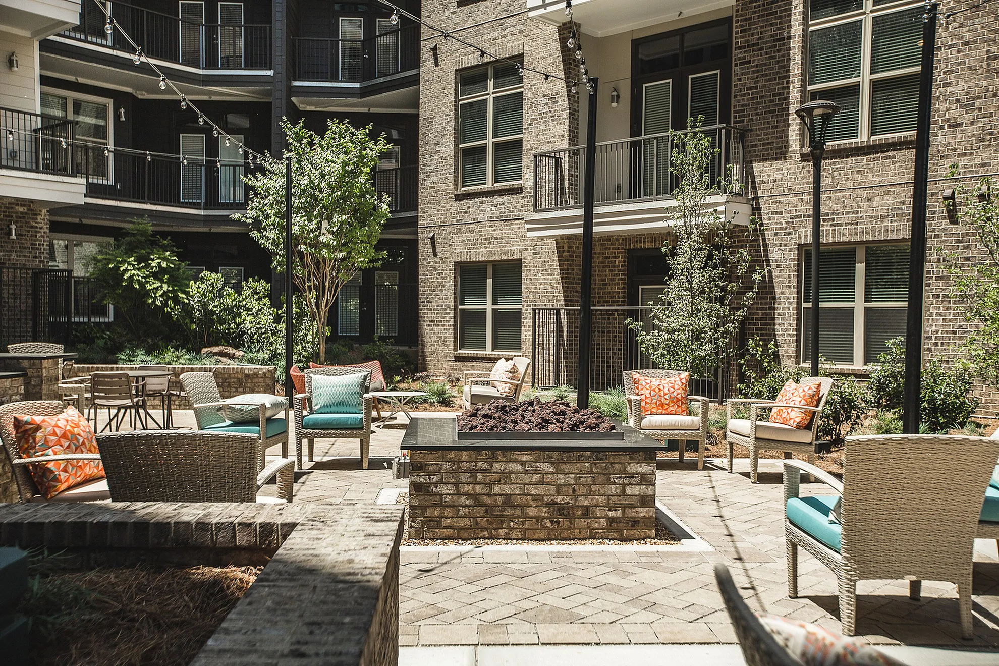 Charming courtyard featuring cozy outdoor seating, ambient string lights, and lush greenery, perfect for relaxation and gatherings.