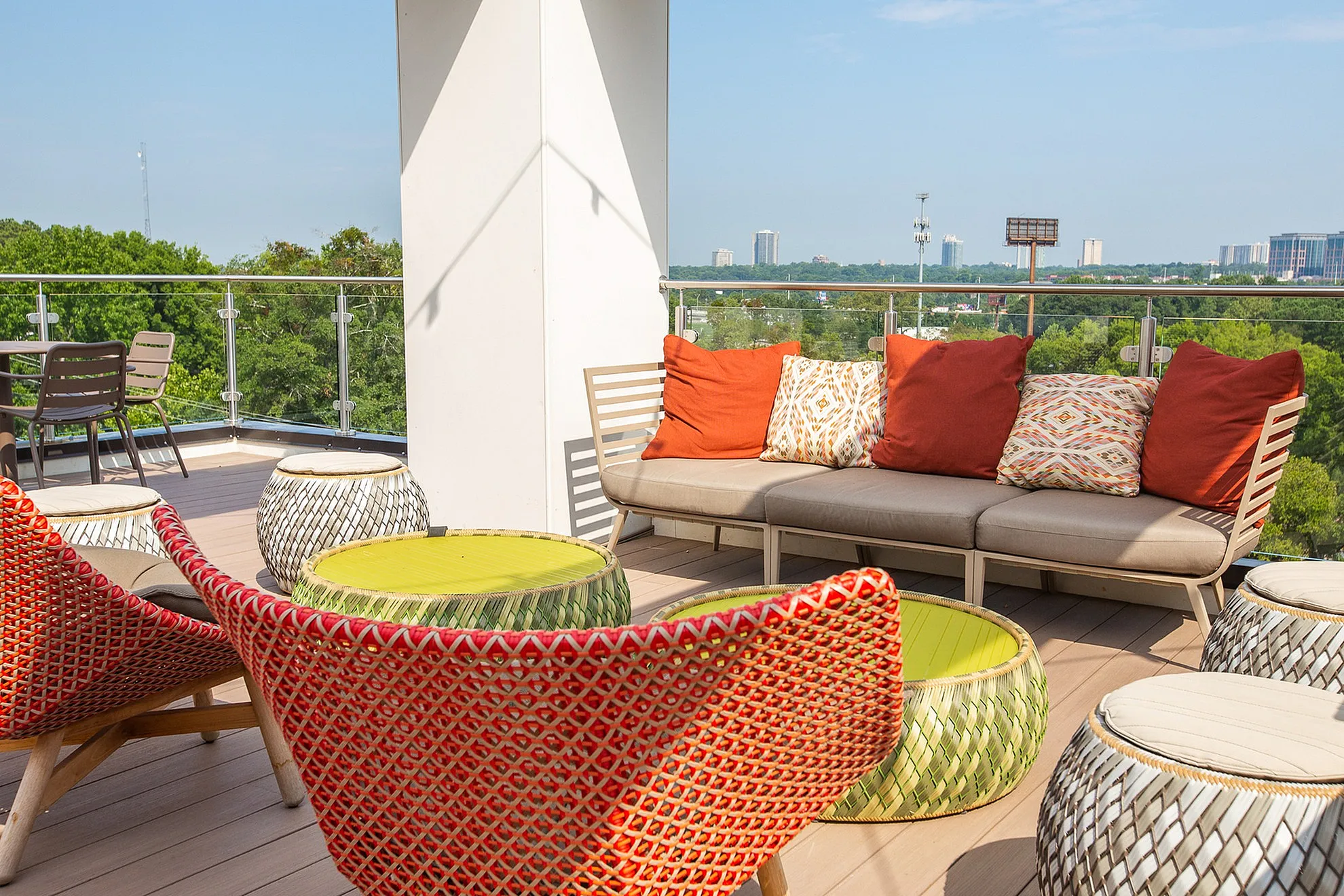 Chic rooftop terrace with vibrant seating, accent pillows, and stunning skyline views.