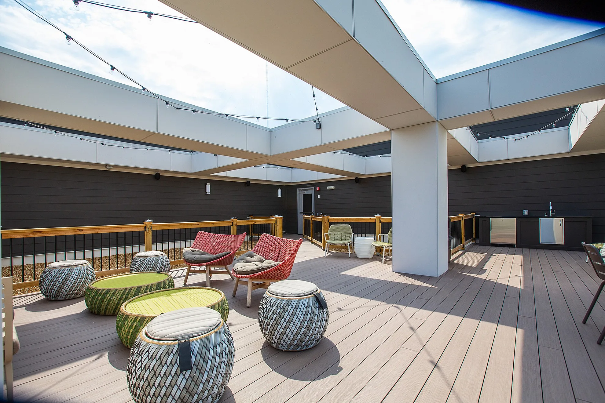 Chic rooftop terrace with modern seating, string lights, and an outdoor kitchenette, ideal for urban relaxation.