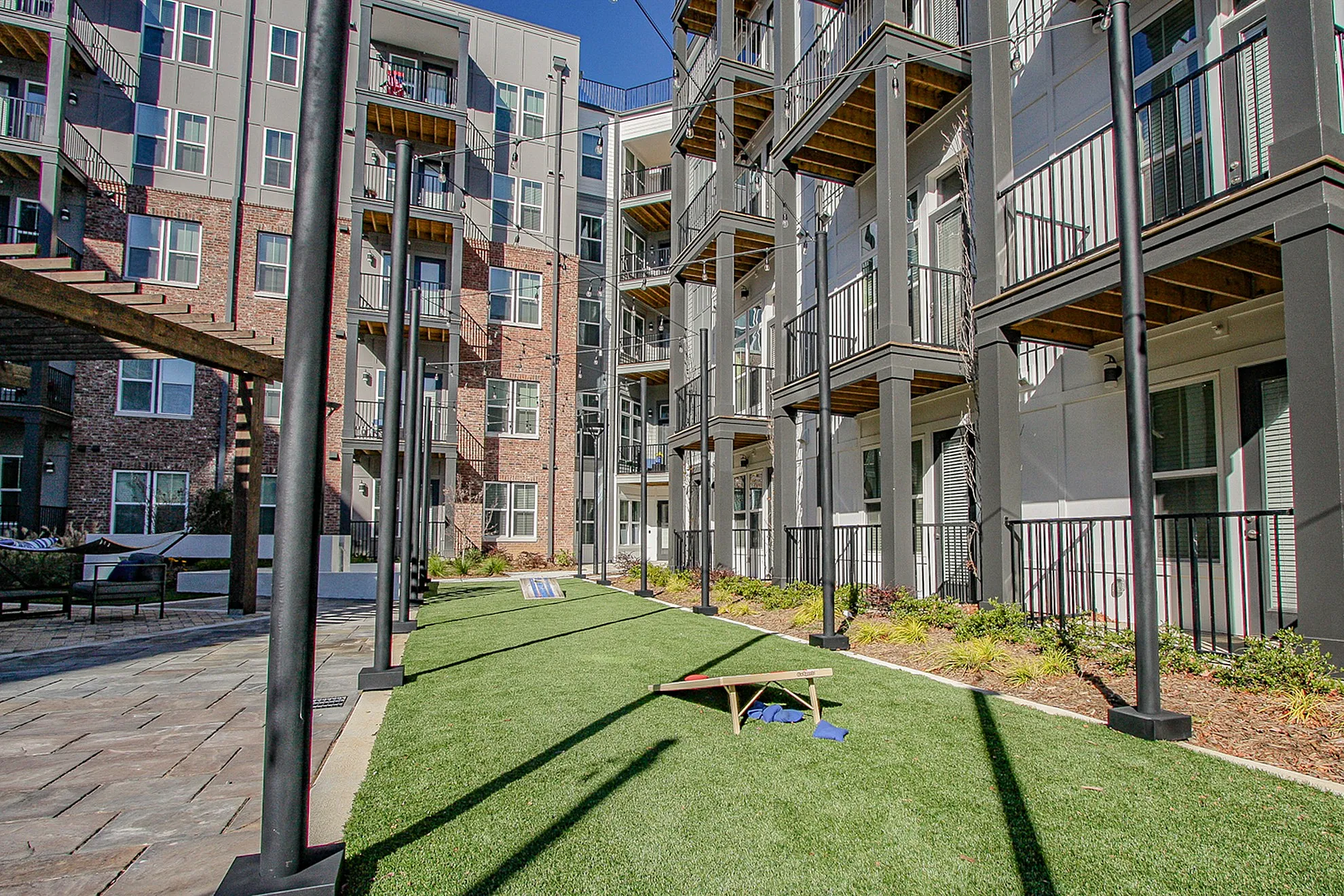 Modern apartment building with private balconies and well-maintained recreational green space, perfect for outdoor activities.
