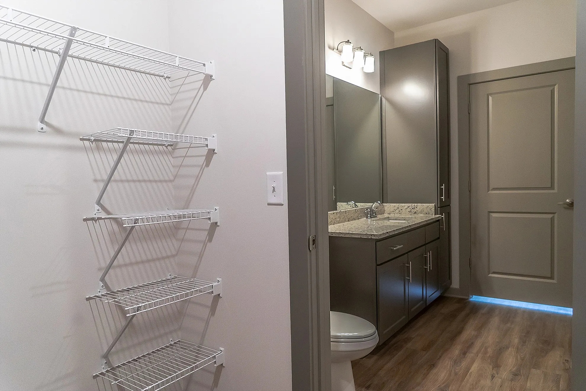 Modern bathroom with elegant granite countertop, sleek cabinetry, and ample shelving for convenient storage.