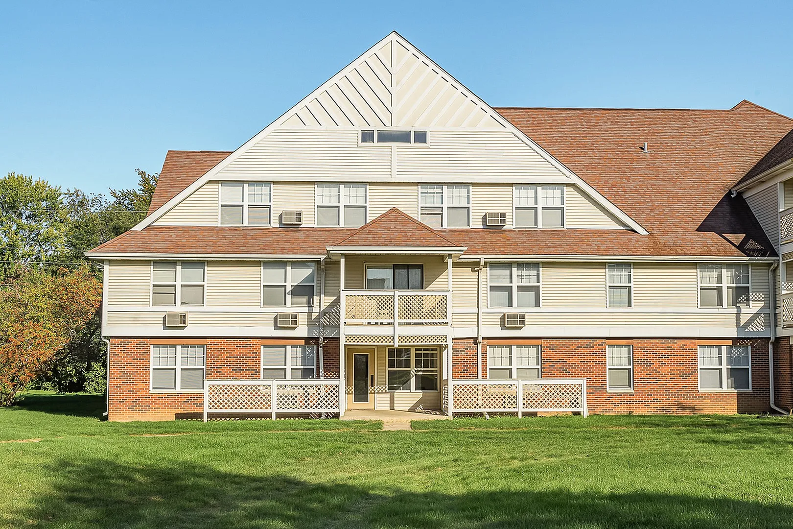 Charming residential building with classic architecture, featuring elegant balconies and surrounded by lush greenery.