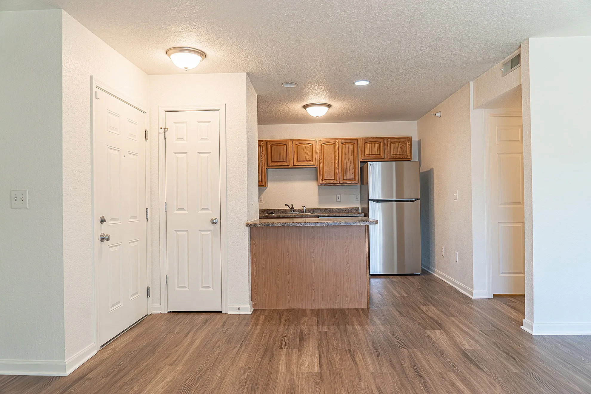 Inviting modern kitchen with sleek countertops, warm wooden cabinets, and stainless steel appliances in a cozy open-plan setting.
