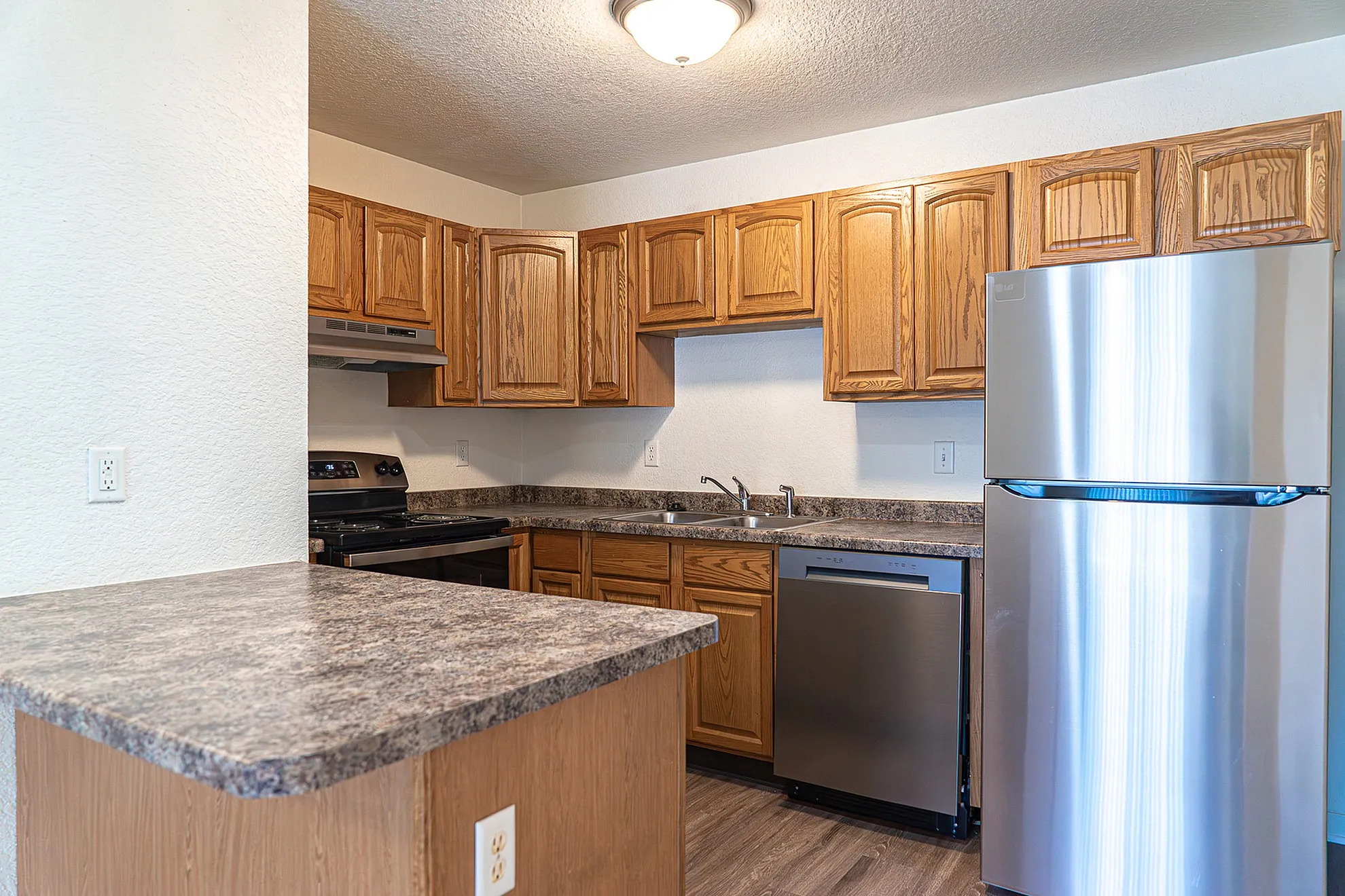 Inviting kitchen with modern appliances, elegant wood cabinetry, and sleek countertops, perfect for culinary creativity.