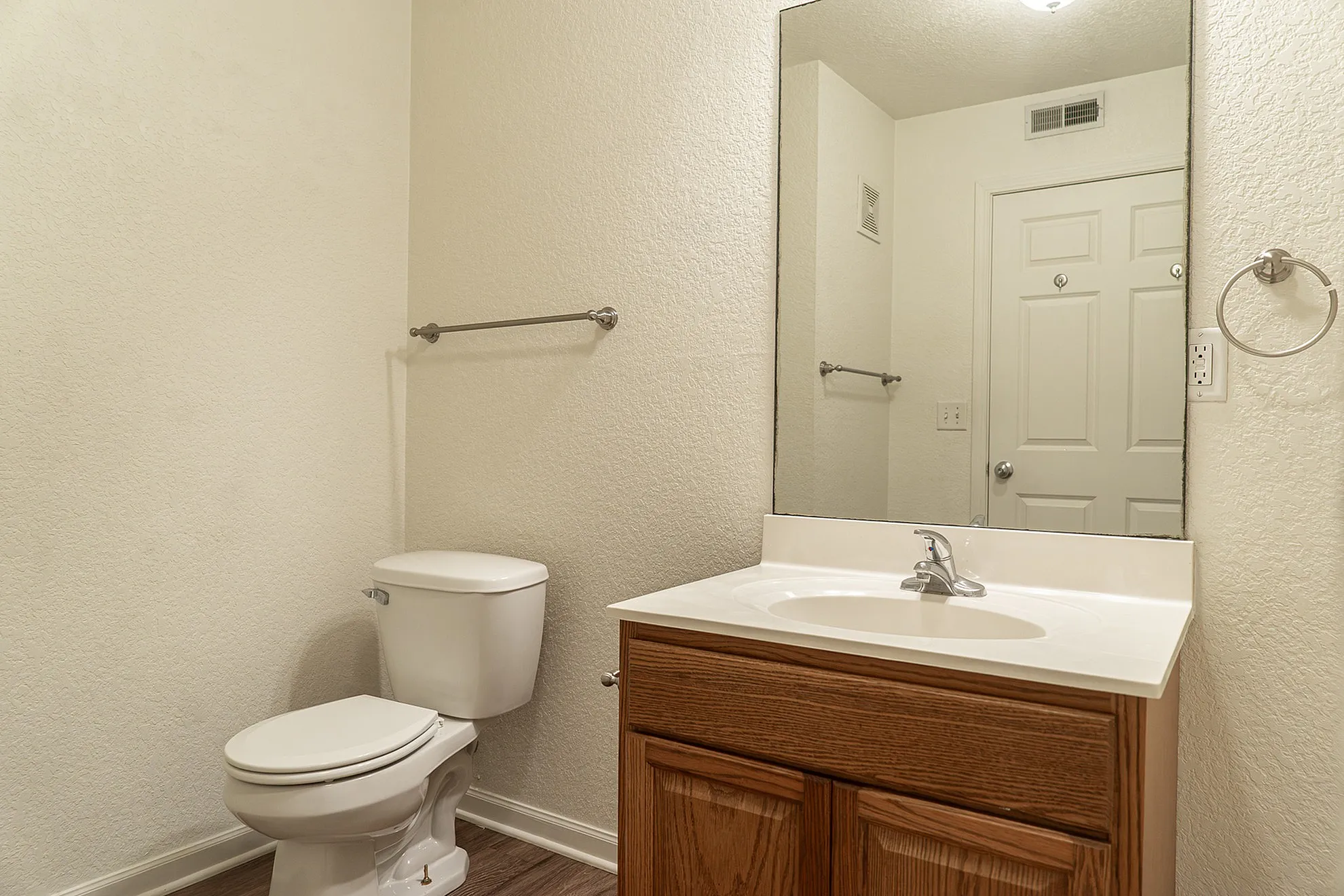 Inviting bathroom with modern fixtures, elegant wood cabinetry, and a large mirror enhancing the space.