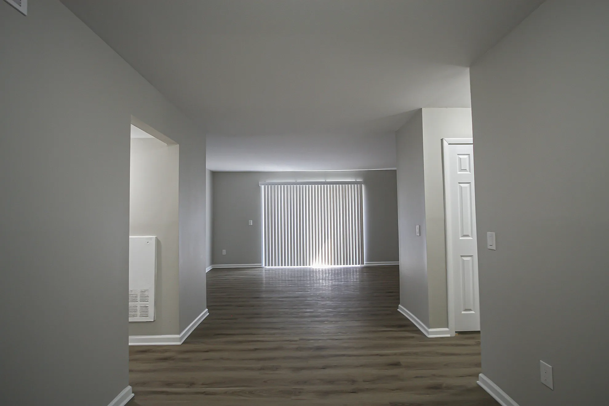 Inviting living space with sleek wooden floors, abundant natural light, and modern neutral walls.